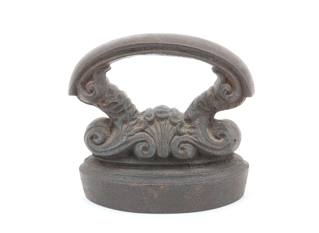 CAST IRON CAP IRON: ORNATE CAST HANDLE. 3 1/8" BASE LENGTH. PLEASE READ CAREFULLY - ITEMS MUST BE PAID FOR THROUGH LIVE AUCTIONEERS OR WITH CASH OR CHECK IN PERSON - Terms for Purchasing and Shipping of Auction Items.