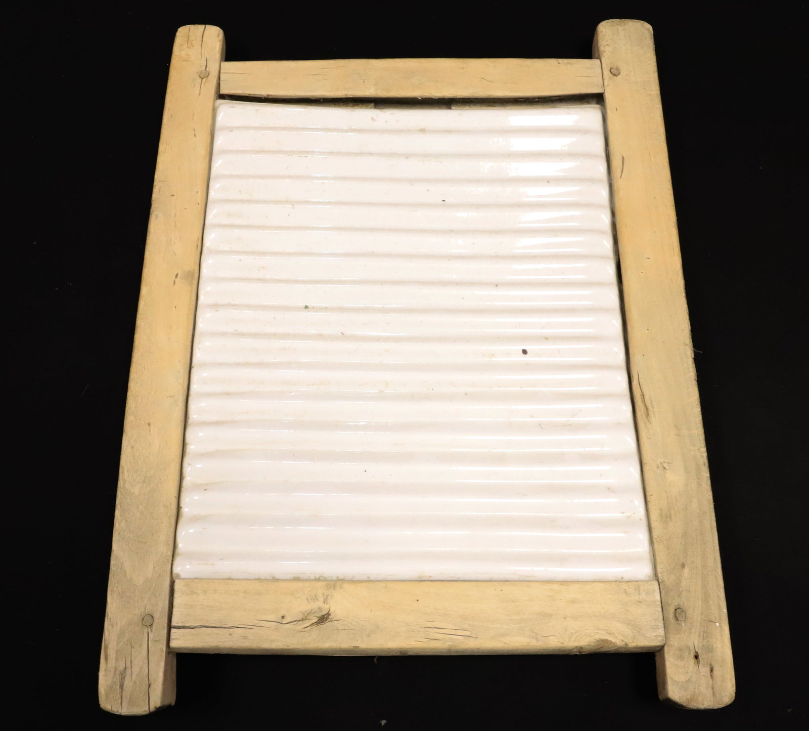 ANTIQUE WASHBOARD WITH POTTERY INSERT: IRONSTONE OR HEAVY PORCELAIN RIBBED INSERT. WOODEN FRAMEWORK HAS PEGGED CONSTRUCTION. 18" X 13 1/2". PLEASE READ CAREFULLY - ITEMS MUST BE PAID FOR THROUGH LIVE AUCTIONEERS OR WITH CASH OR CHECK IN