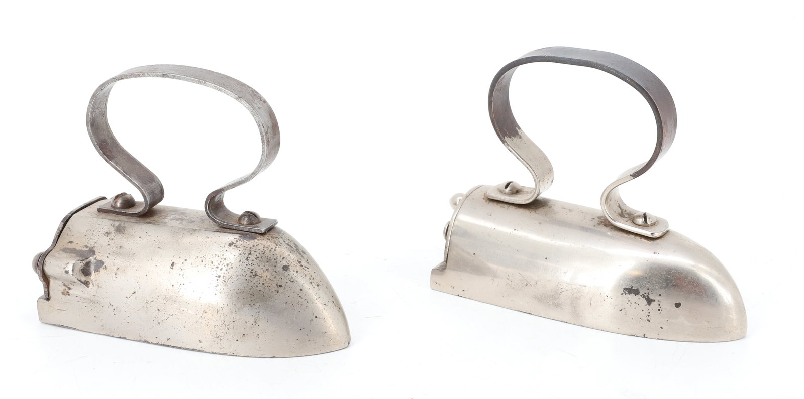 (2) SMALL SIZE OX-TONGUE IRONS: NICKEL FINISH IRONS WITH STRAP HANDLES AND REAR SWING GATES. ONE WITH INTERIOR SLUG. 4 1/2" L. PLEASE READ CAREFULLY - ITEMS MUST BE PAID FOR THROUGH LIVE AUCTIONEERS OR WITH CASH OR CHECK IN PERSON