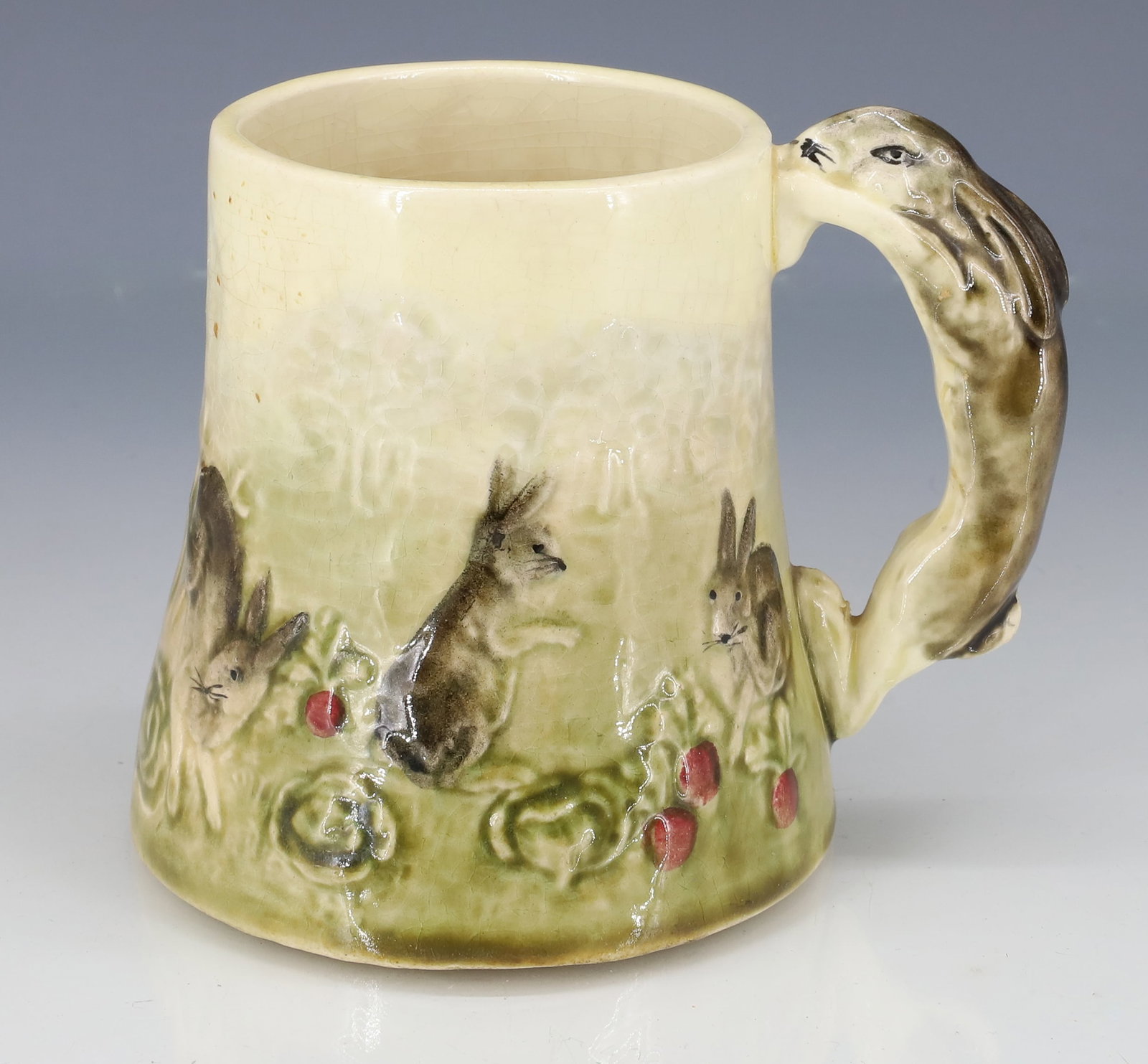 FRENCH MAJOLICA RABBIT MUG: MARKED; MADE IN FRANCE, FOR "HIGGINS & SEITER NEW YORK" - DEPICTS EMBOSSED AND PAINTED RABBITS WITH RABBIT HANDLE - 3 5/8" X 3 5/8" PLEASE READ CAREFULLY - ITEMS MUST BE PAID FOR THROUGH LIVE AUCTIONE