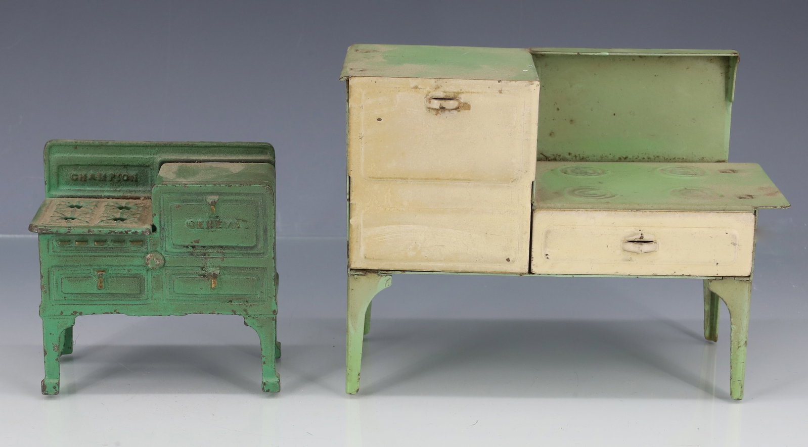 (2) MINIATURE STOVES: INCLUDING; PAINTED CAST IRON MARKED; CHAMPION, GENEVA 3" X 3 1/4" X 2 3/4" - AND PAINTED PRESSED METAL EXAMPLE IN GREEN AND CREAM 4 1/2" X 6" X 2 3/4" PLEASE READ CAREFULLY - ITEMS MUST BE PAID FOR TH