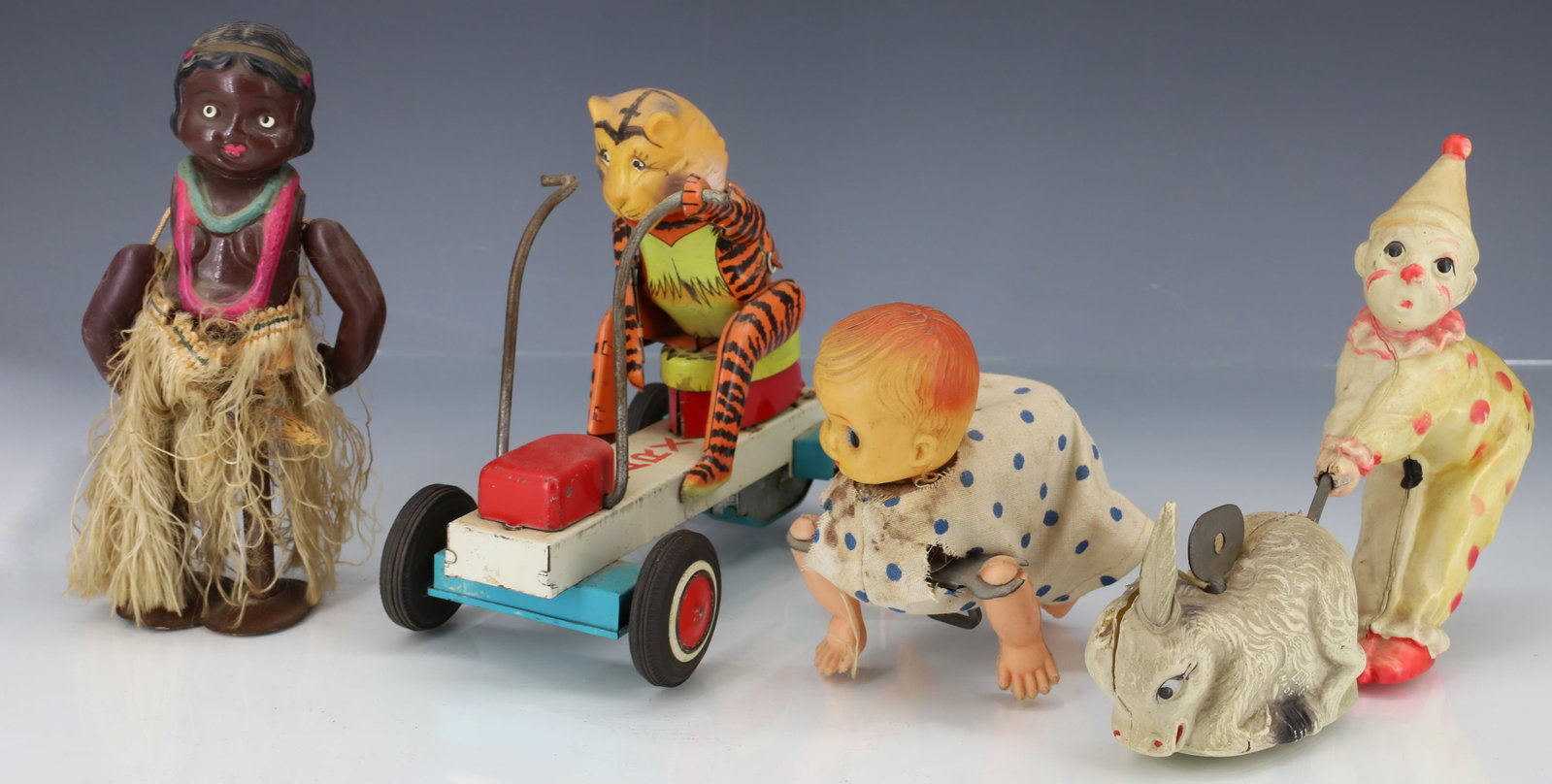 (4) CELLULOID AND TIN TOYS: INCLUDING; MARX FRICTION TOY WITH TIGER 6", CELLULOID CLOWN WITH DONKEY, CRAWLING BABY, AND HULA GIRL PLEASE READ CAREFULLY - ITEMS MUST BE PAID FOR THROUGH LIVE AUCTIONEERS OR WITH CASH OR CHECK IN P
