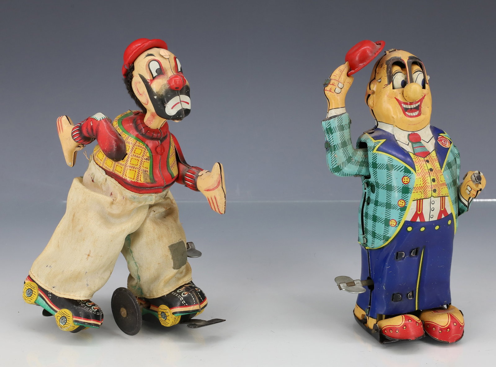 (2) TIN LITHO TOY WINDUPS: CLOWN ON ROLLER SKATES (MRKD. TPS , JAPAN) 6" H. WITH, MAN IN SUIT WITH HAT IN HAND. (JAPAN) 6" H. PLEASE READ CAREFULLY - ITEMS MUST BE PAID FOR THROUGH LIVE AUCTIONEERS OR WITH CASH OR CHECK IN PERS