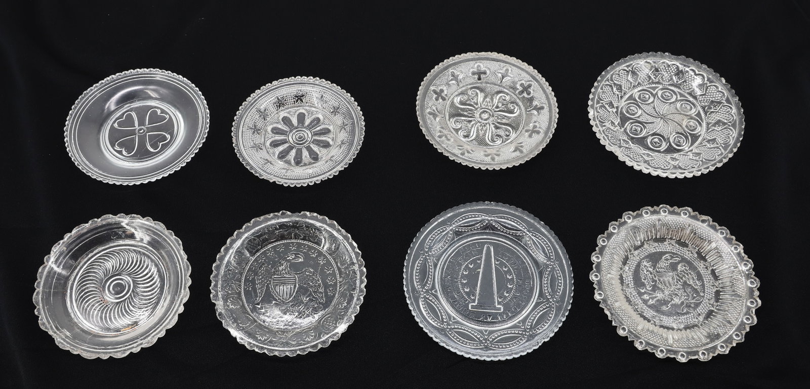LOT OF (8) EAPG CUP PLATES: CLEAR FLINT GLASS CUP PLATES WITH VARIOUS PATTERNS INCLUDING: EAGLE AND BUNKER HILL. 3" TO 3 1/2" DIAMETERS. PLEASE READ CAREFULLY - ITEMS MUST BE PAID FOR THROUGH LIVE AUCTIONEERS OR WITH CASH OR CHE