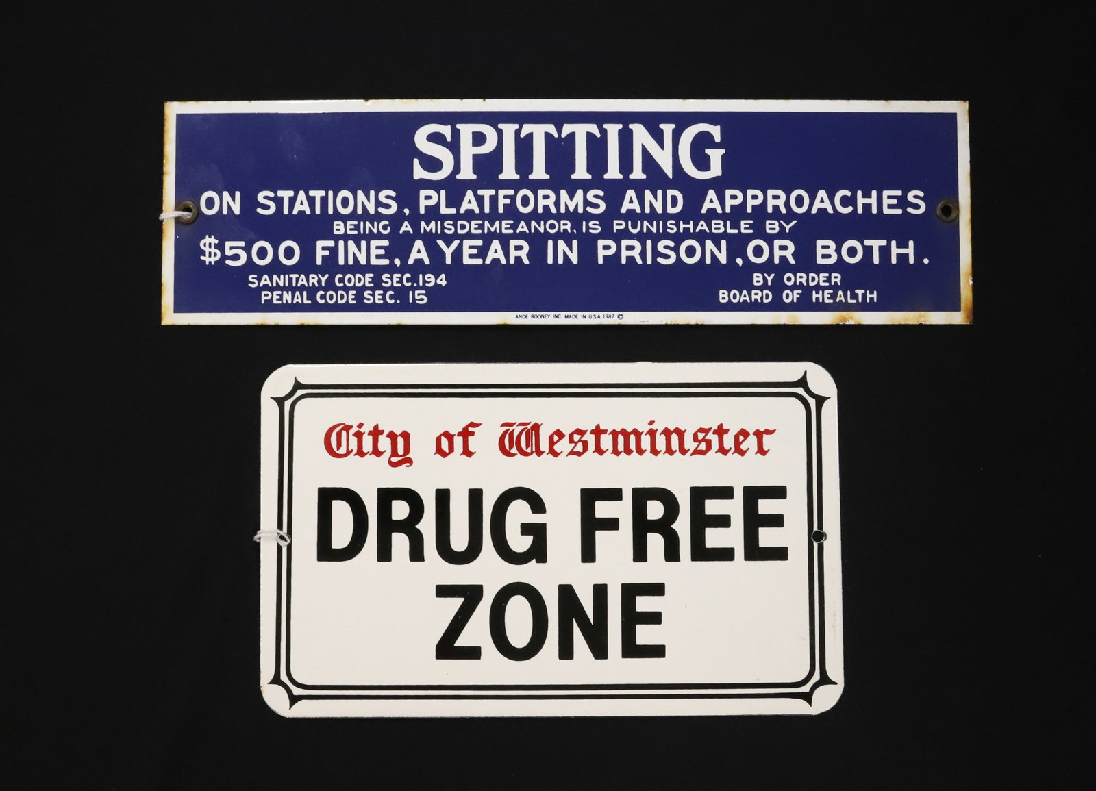 (2) PORCELAIN SIGNS: CONTEMPORARY SIGNS INCLUDING: "CITY OF WESTMINSTER DRUG FREE ZONE" 5" X 8 1/2". WITH, "SPITTING ON STATIONS, PLATFORMS...." ANDE ROONEY, 1987. 3 1/4" X 12". PLEASE READ CAREFULLY - ITEMS MUST BE PAID 