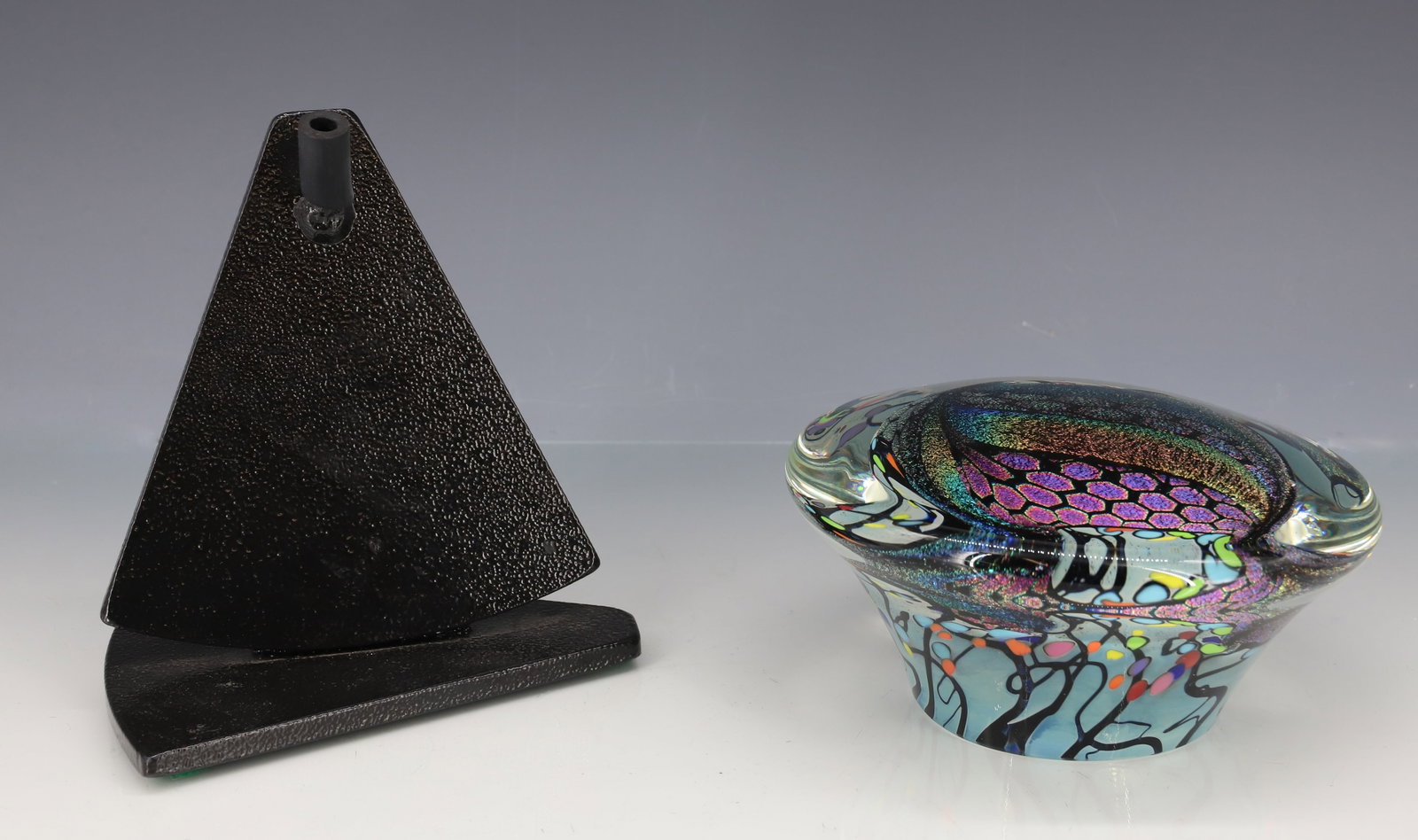 ROLLIN KARG PAPERWEIGHT: IRIDESCENT BLUE-GREEN COLORS IN HONEYCOMB AND STAR PATTERNS WITH BLACK IRON STAND SIGNED ROLLIN KARG 2018 8" X 5 1/2" 5 1/2" DIA PLEASE READ CAREFULLY - ITEMS MUST BE PAID FOR THROUGH LIVE
