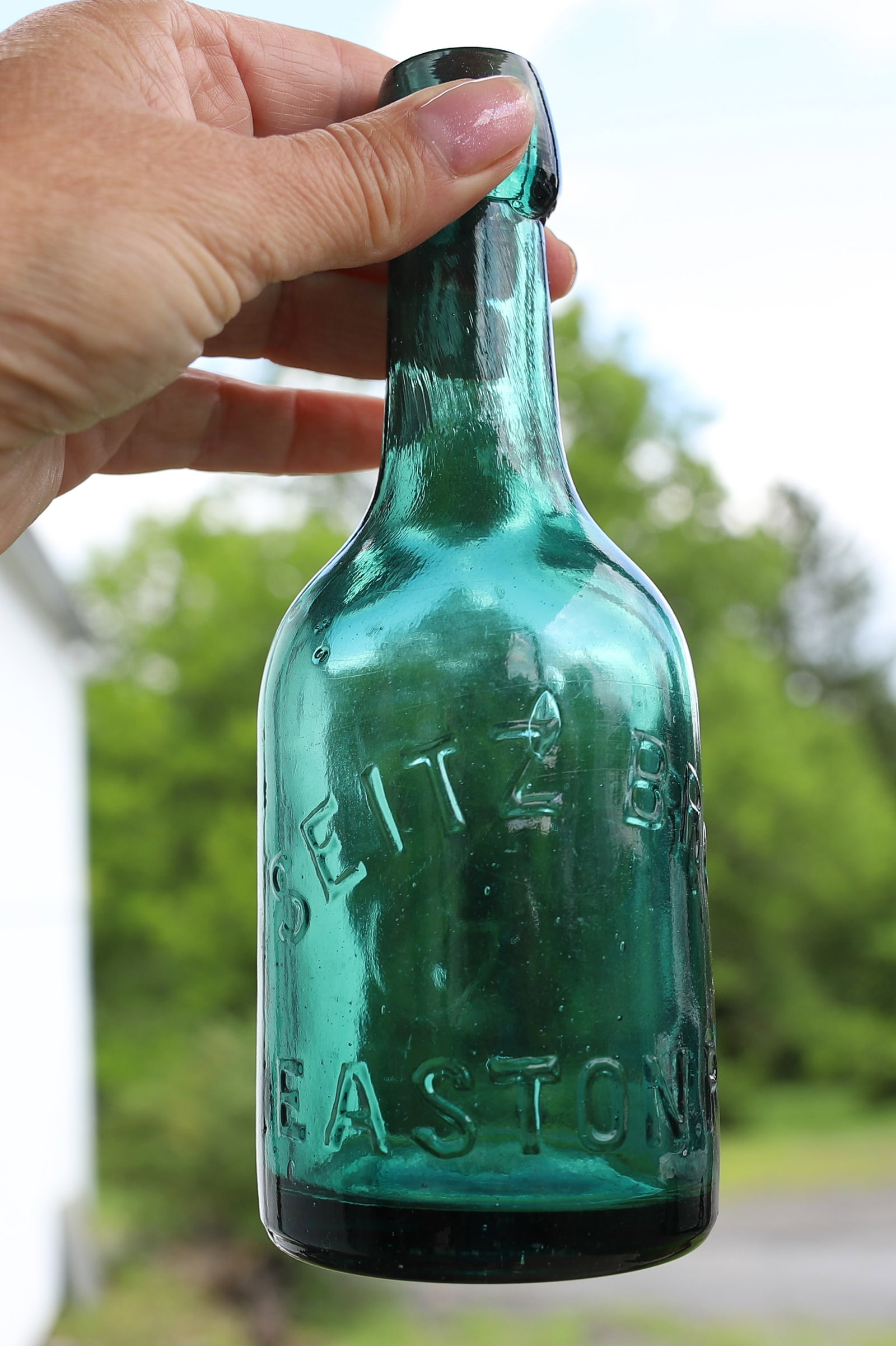 SEITZ BROS. EASTON, PA BOTTLE: GREEN BOTTLE WITH EMBOSSED NAME. LARGE "S" ON BACK. 7" H. PLEASE READ CAREFULLY - ITEMS MUST BE PAID FOR THROUGH LIVE AUCTIONEERS OR WITH CASH OR CHECK IN PERSON - Terms for Purchasing and Shipping