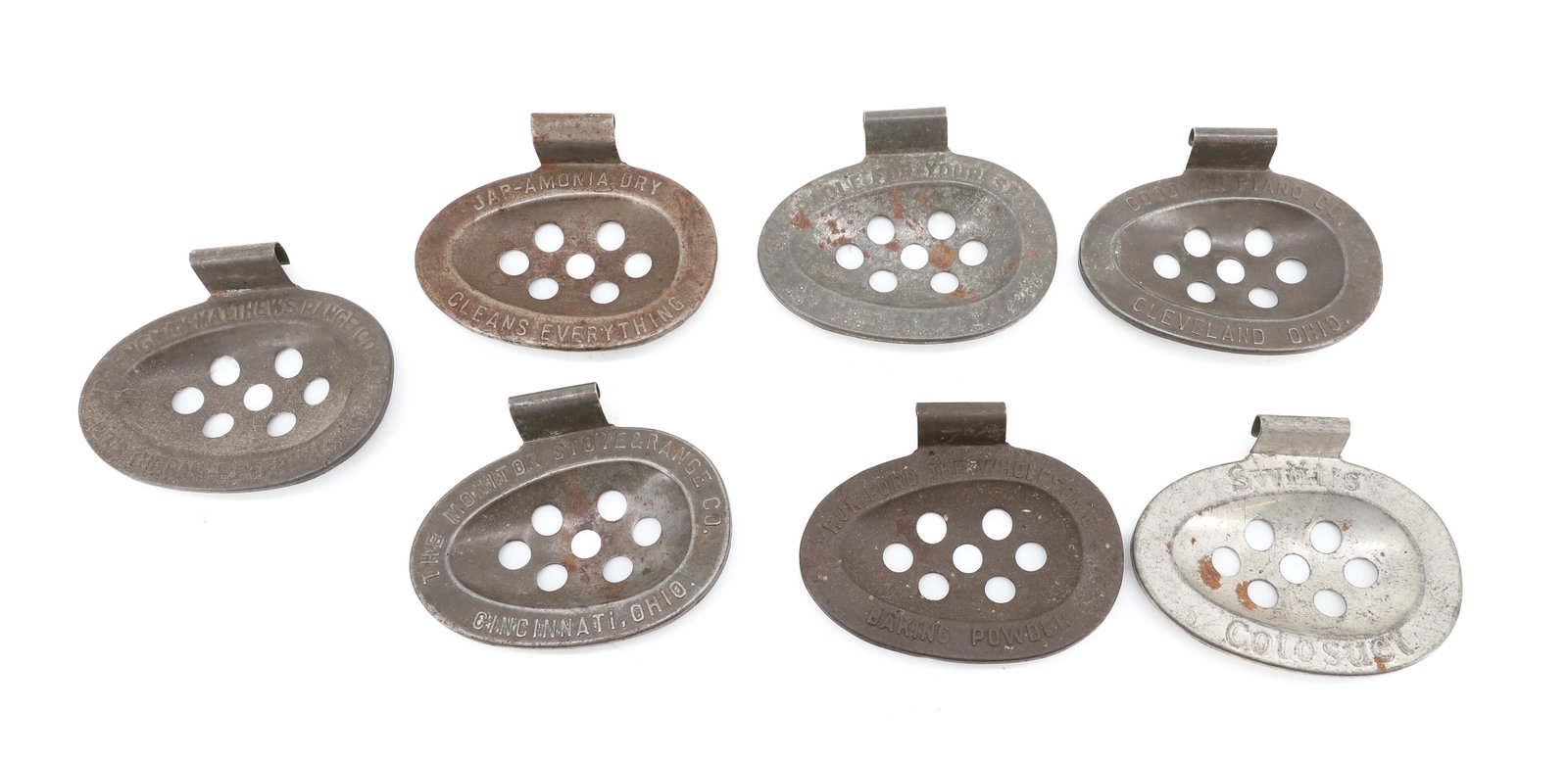 LOT OF (7) ADVERTISING SPOON HOLDERS: EMBOSSED TIN SPOON HOLDERS ATTACH TO SIDE OF POT. ADVERTISEMENTS INCLUDING: RUMFORD BAKING POWDER. GOODMAN PIANO CO.. MONITOR STOVE & RANGE. JAP-AMONIA DRY. SWIFT'S COTOSUET. AND MORE. PLEASE READ