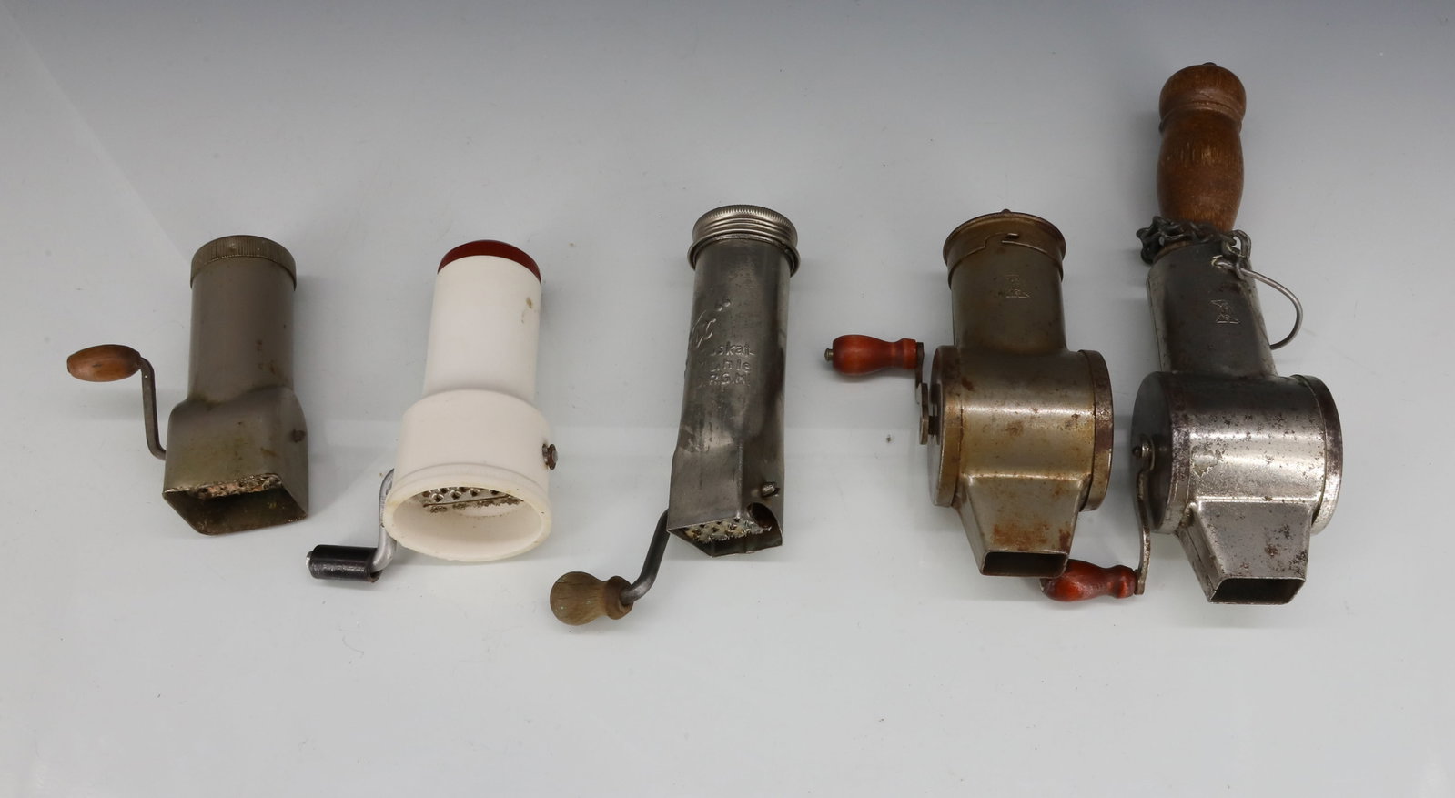LOT OF (5) ANTIQUE NUTMEG GRATERS: INCLUDING: TWO MRKD. "MTE" INSIDE DIAMOND SHAPE. 3 5/8" LENGTHS. ONE MRKD. "FIX" (D.R.G.M.) MOLDED PLASTIC WITH BURGUNDY CAP MRKD. "DRGM". SMALLEST MRKD. "MUSCAINUSS". PLEASE READ CAREFULLY - ITEMS MU