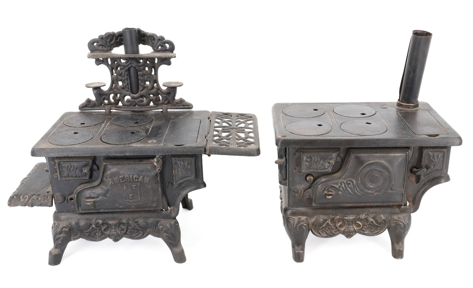 (2) CAST IRON TOY STOVES: AMERICAN ATF FOUR-BURNER WITH END SHELVES 6" X 13" X 6" (HAS RUBBER STOVE PIPE). WITH, CAST IRON FOUR BURNER W/ SKILLET. PLEASE READ CAREFULLY - ITEMS MUST BE PAID FOR THROUGH LIVE AUCTIONEERS OR WITH