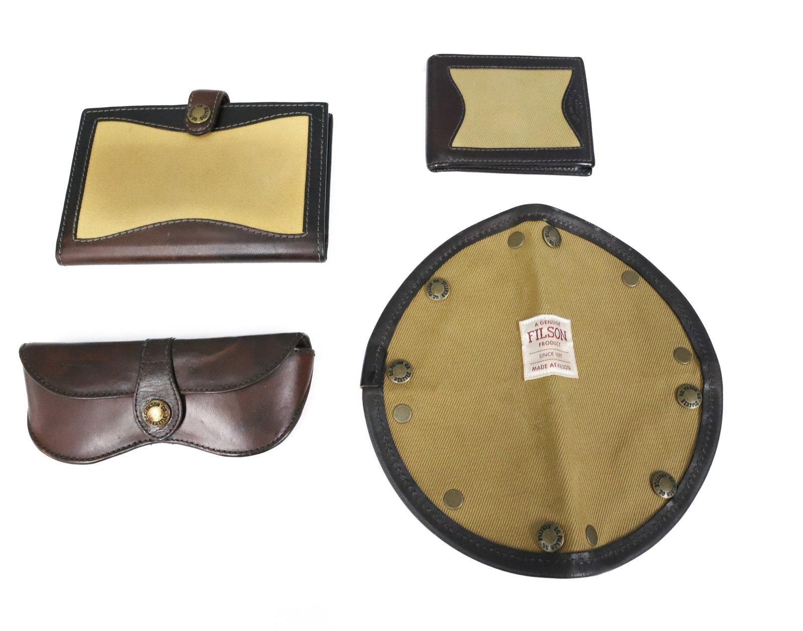 LOT OF (4) FILSON ACCESSORIES: TWILL CANVAS WALLET, TRAVEL TRAY AND LEADER WALLET 6 1/2" X 4 1/2". WITH, LEATHER SUNGLASS CASE. PLEASE READ CAREFULLY - ITEMS MUST BE PAID FOR THROUGH LIVE AUCTIONEERS OR WITH CASH OR CHECK IN