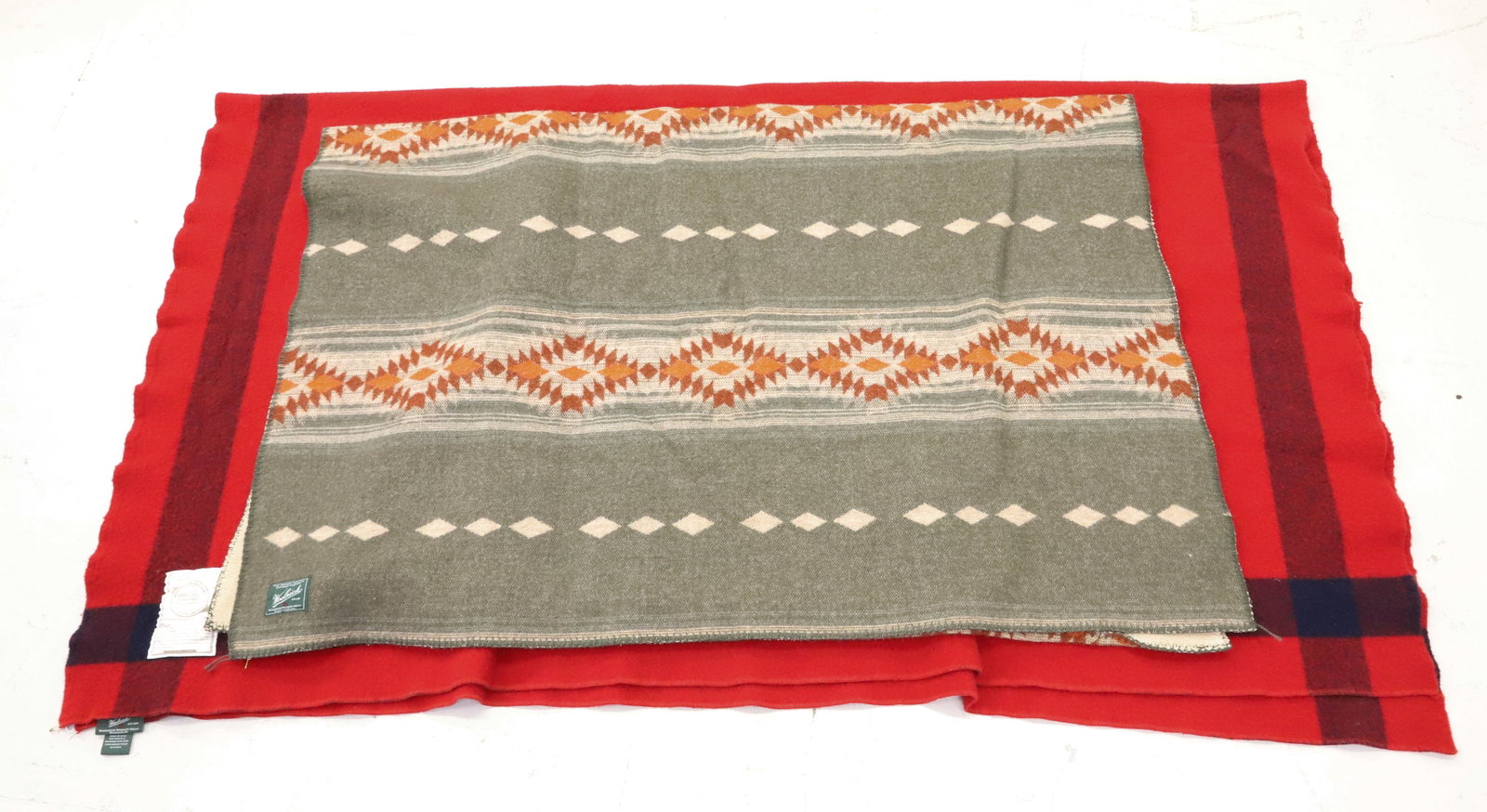 (2) WOOLRICH WOOL BLANKETS: RED W/ BLACK STRIPES. 64" X 70". GREEN / ORANGE / RUST / CREAM NATIVE AMERICAN PATTERN W/ FLEECE ON OPPOSITE. 46" X 62". PLEASE READ CAREFULLY - ITEMS MUST BE PAID FOR THROUGH LIVE AUCTIONEERS OR WITH