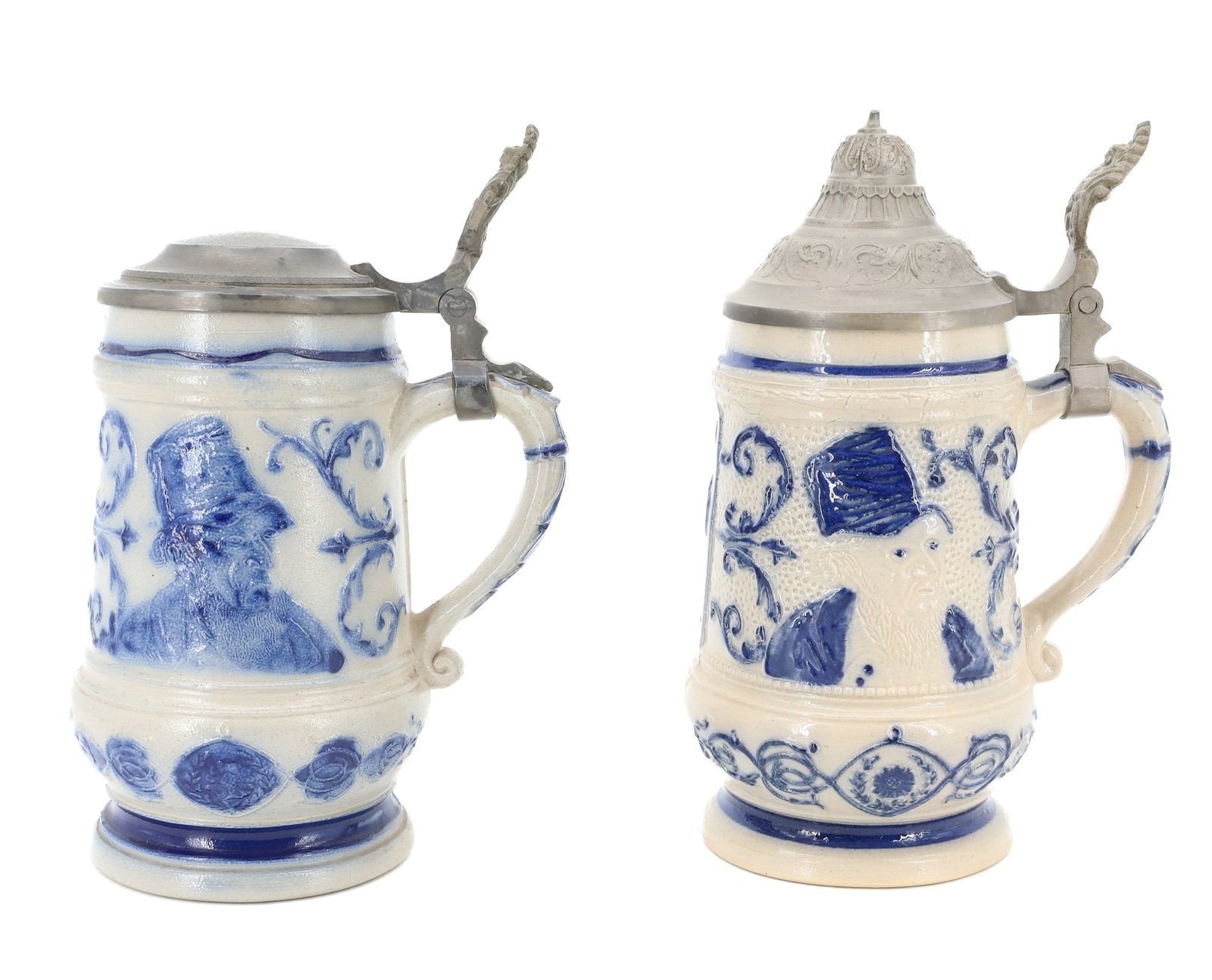 (2) WHITE'S UTICA STONEWARE STEINS: SIMILAR STYLE DECORATIONS OF MAN IN TALL HAT. BOTH HAVE PEWTER LIDS AND MRKD. "37" ON BOTTOM. TOTAL HEIGHTS 8 3/8" AND 8 1/2". (MUGS 6 1/2" H.) PLEASE READ CAREFULLY - ITEMS MUST BE PAID FOR THROUGH