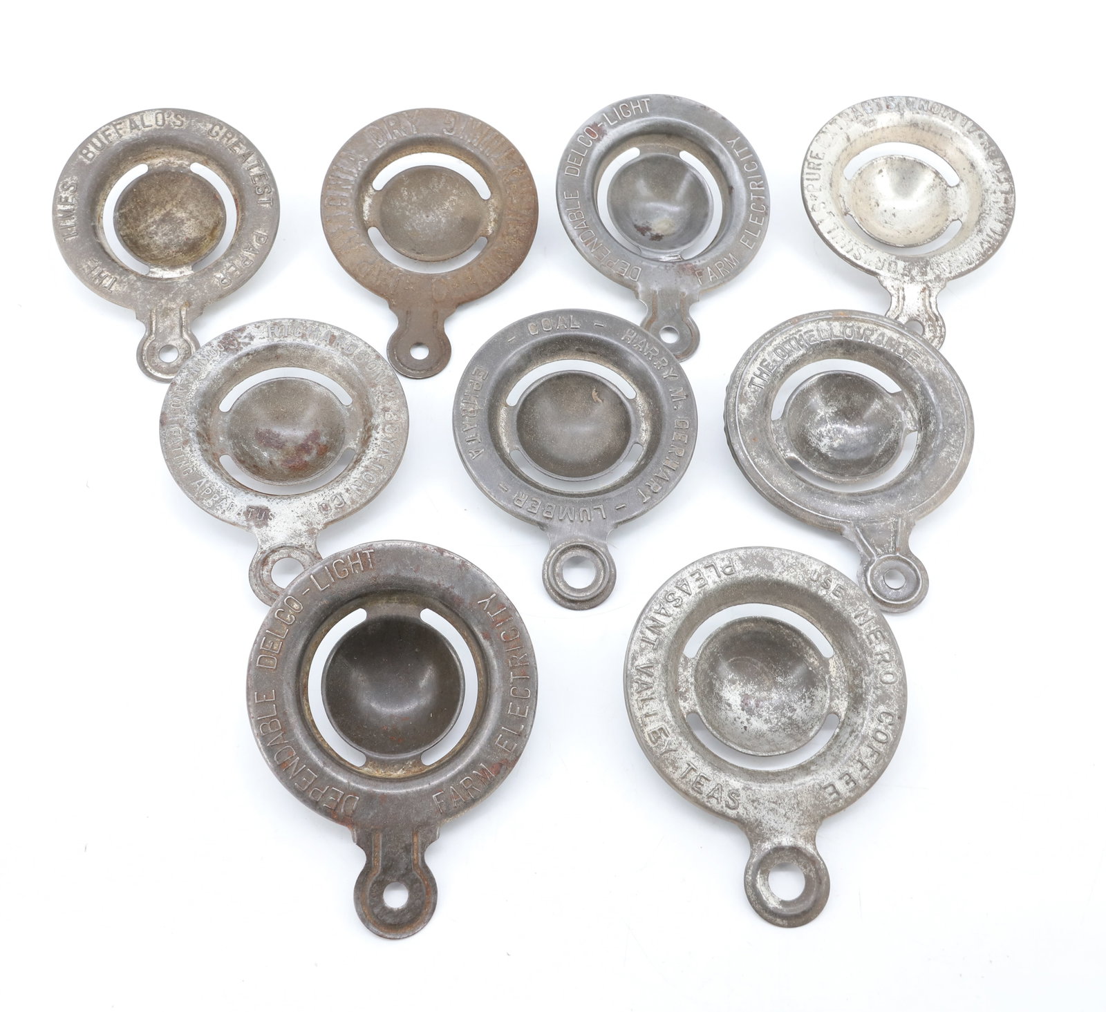 LOT OF TIN ADVERTISING EGG SEPARATORS: (10) EMBOSSED ADVERTISING INCLUDING: DELCO-LIGHT FARM ELECTRICITY, NERO COFFEE, OTHELLO RANGE, GERHART LUMBER, EPHRATA, SHULLS PURE EXTRACTS, SOUTH BEND MALLEABLE RANGE, AND MORE. PLEASE READ