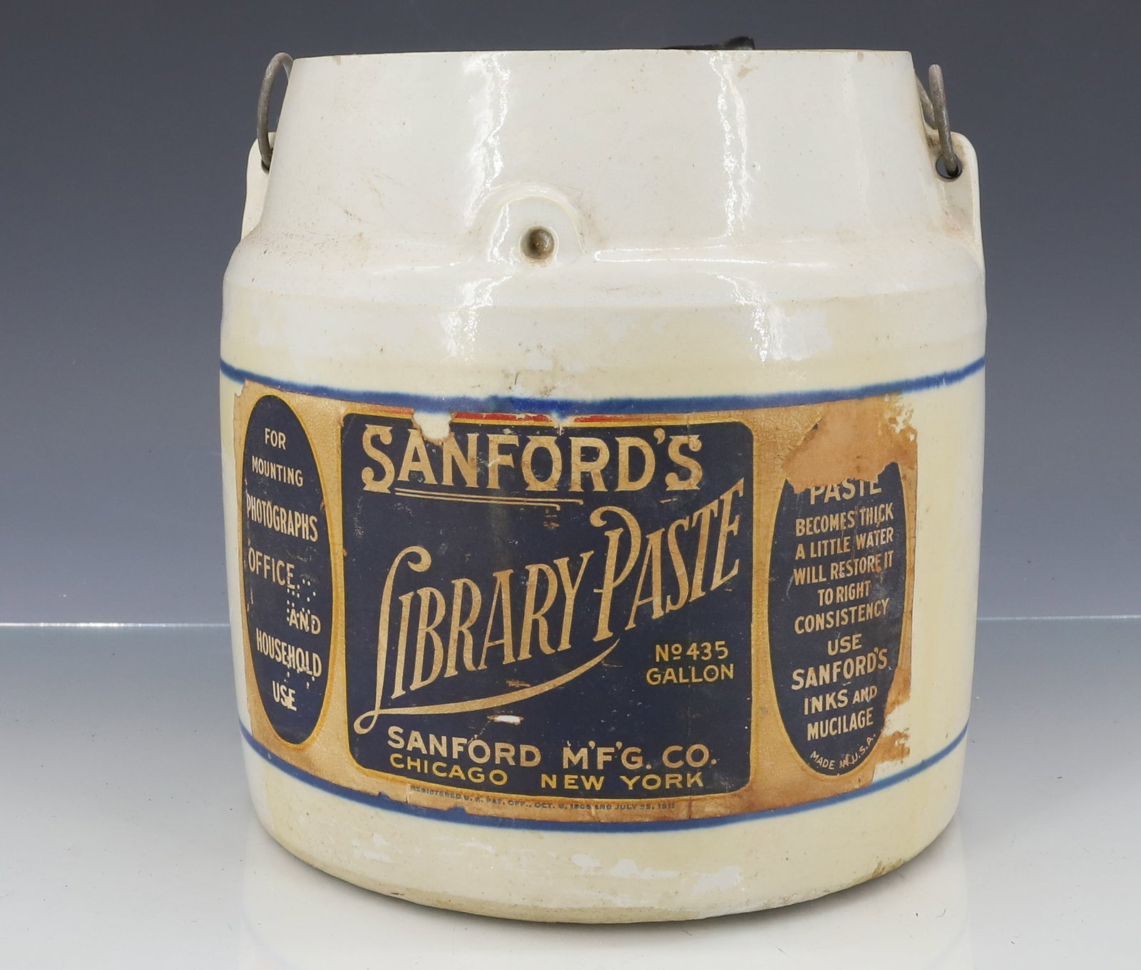"SANFORD'S" INK / PASTE STONEWARE CROCK: ADVERTISING CROCK WITH ORIGINAL PAPER LABEL. BAIL HANDLE. 7 1/2" X 7". MISSING LID. PLEASE READ CAREFULLY - ITEMS MUST BE PAID FOR THROUGH LIVE AUCTIONEERS OR WITH CASH OR CHECK IN PERSON - Terms for