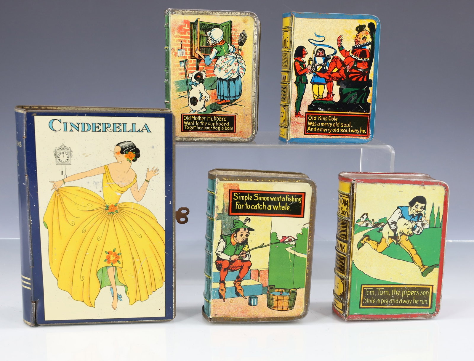(5) TIN LITHO BOOK BANKS: LARGEST IS "CINDERELLA" WITH KEY. 5 5/8" X 4". (4) NURSERY RHYME THEMED BOOK BANKS 3 7/8" X 3". VOLUMES 1 TO 4. MRKD. PAT. KIRCHOF, NEWARK, NJ. PLEASE READ CAREFULLY - ITEMS MUST BE PAID FOR THROUGH