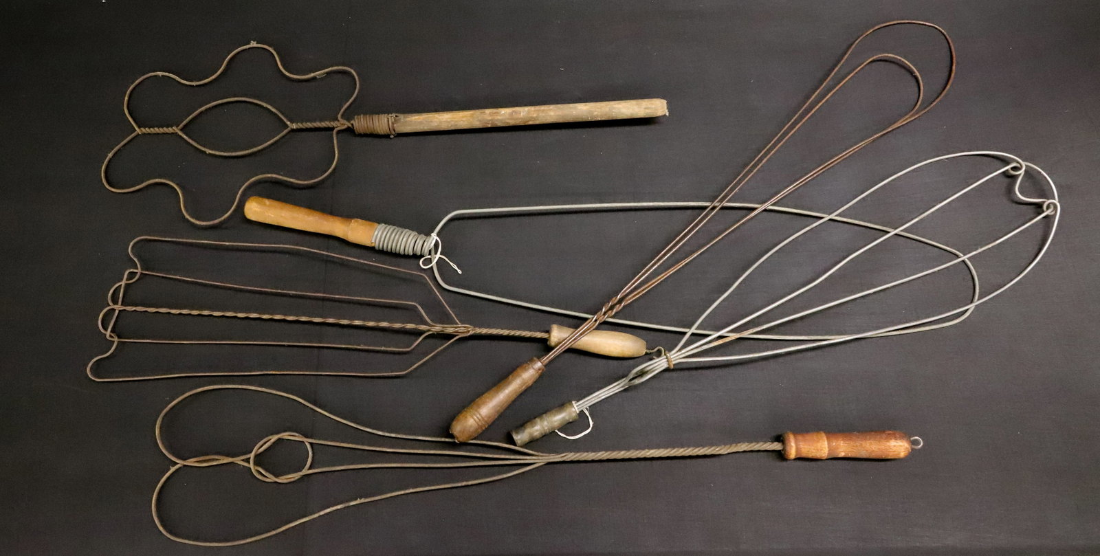 LOT OF ANTIQUE RUG BEATERS: WIRE CONSTRUCTION WITH WOODEN HAND GRIPS. SOME UNUSUAL FORMS. 34 1/2" L. PLEASE READ CAREFULLY - ITEMS MUST BE PAID FOR THROUGH LIVE AUCTIONEERS OR WITH CASH OR CHECK IN PERSON - Terms for Purchasing