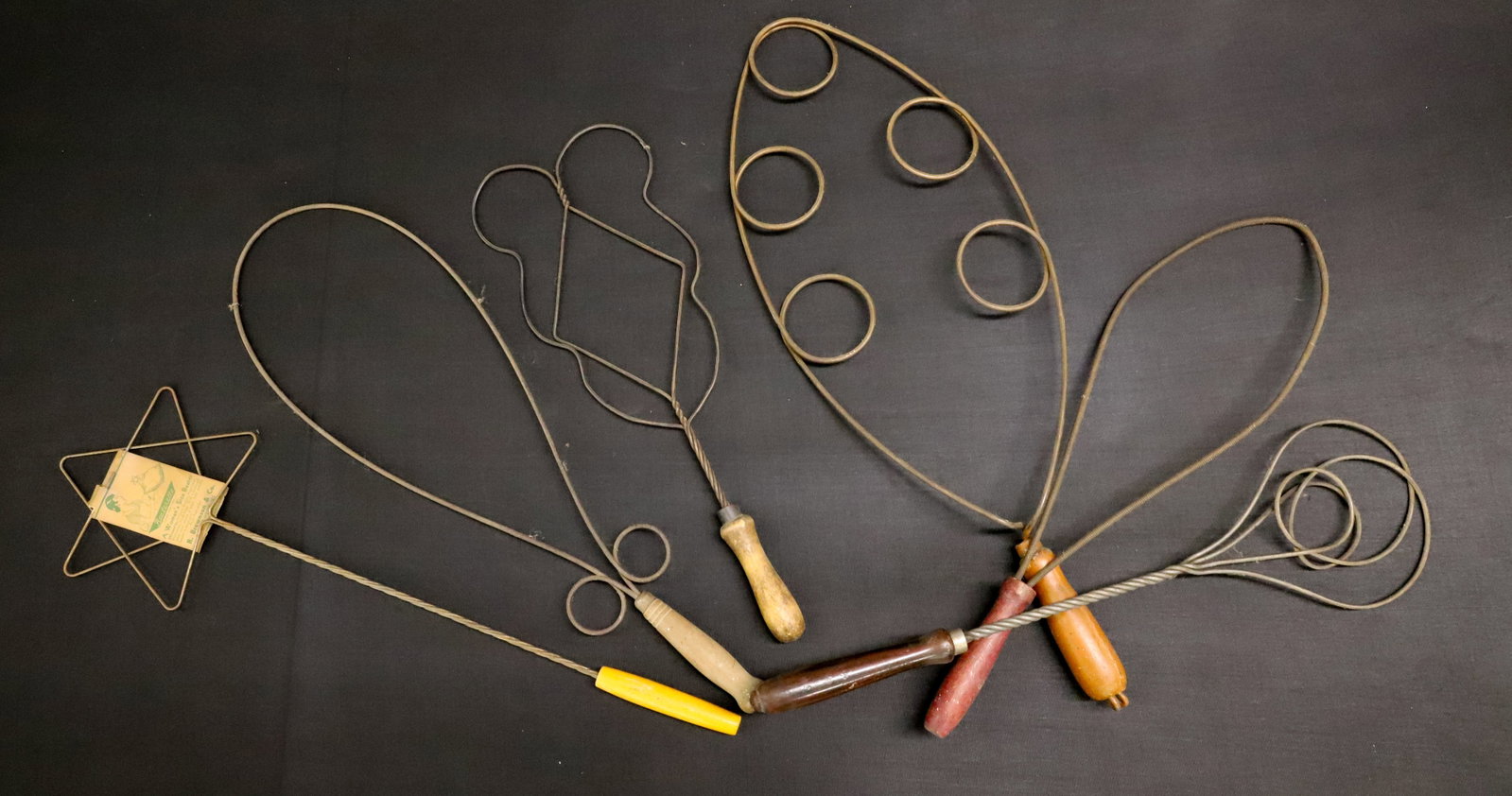 LOT OF ANTIQUE RUG / PILLOW BEATERS: SMALL SIZE WIRE FORMS WITH WOODEN HAND GRIPS. LARGEST 23" L. ONE WITH ORIGINAL TAG. PLEASE READ CAREFULLY - ITEMS MUST BE PAID FOR THROUGH LIVE AUCTIONEERS OR WITH CASH OR CHECK IN PERSON - Terms for