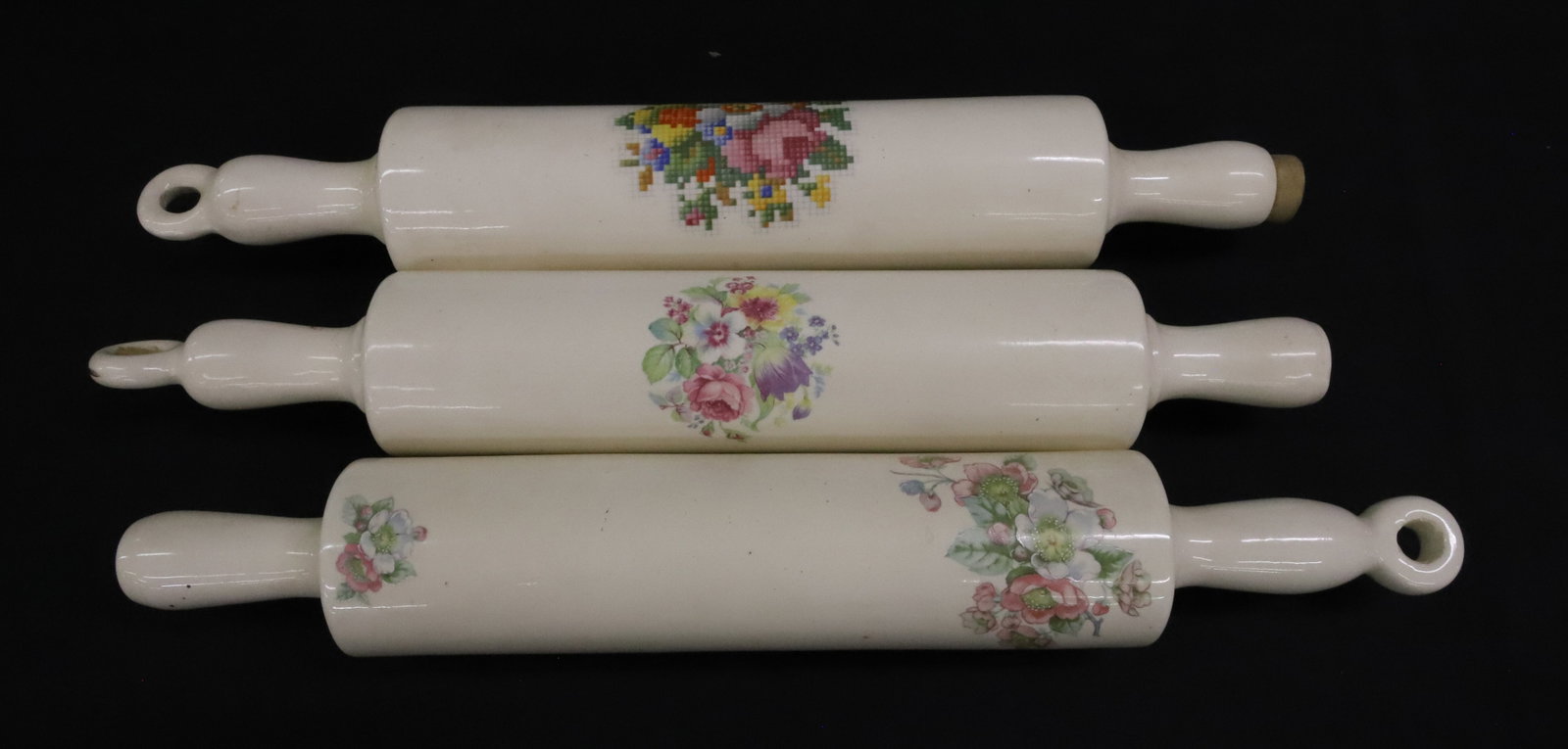 (3) CERAMIC ROLLING PINS: FLORAL MOTIFS ON IVORY COLOR BODY. ONE MRKD. "HOTOVEN CHINA...DECORATIVE USE ONLY" 15 1/2" L. PLEASE READ CAREFULLY - ITEMS MUST BE PAID FOR THROUGH LIVE AUCTIONEERS OR WITH CASH OR CHECK IN PERSON -