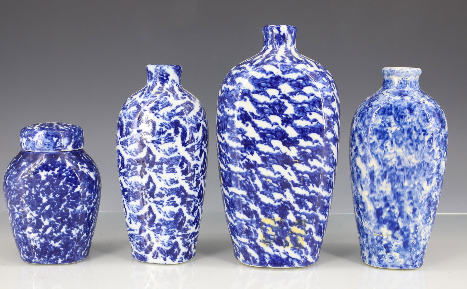(4) BLUE / WHITE SPONGEWARE FLASKS, BOTTLES: SMALLEST HAS FITTED LID 4 1/2" H. THREE ARE MRKD. "MADE IN BAVARIA". LARGEST 7 3/4" H. PLEASE READ CAREFULLY - ITEMS MUST BE PAID FOR THROUGH LIVE AUCTIONEERS OR WITH CASH OR CHECK IN PERSON - Terms