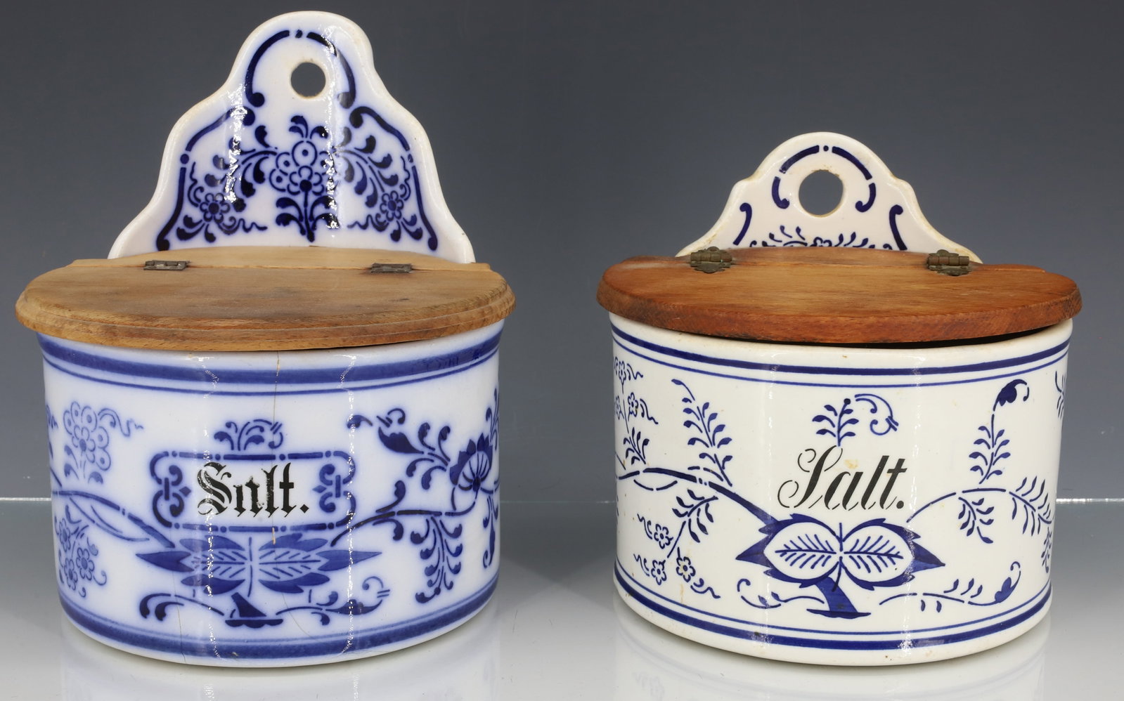 (2) BLUE/WHITE HANGING SALT HOLDERS: BLUE ONION-TYPE MOTIFS WITH HINGED WOODEN LIDS. BOTH STAMPED ON BOTTOM. PLEASE READ CAREFULLY - ITEMS MUST BE PAID FOR THROUGH LIVE AUCTIONEERS OR WITH CASH OR CHECK IN PERSON - Terms for Purchasing