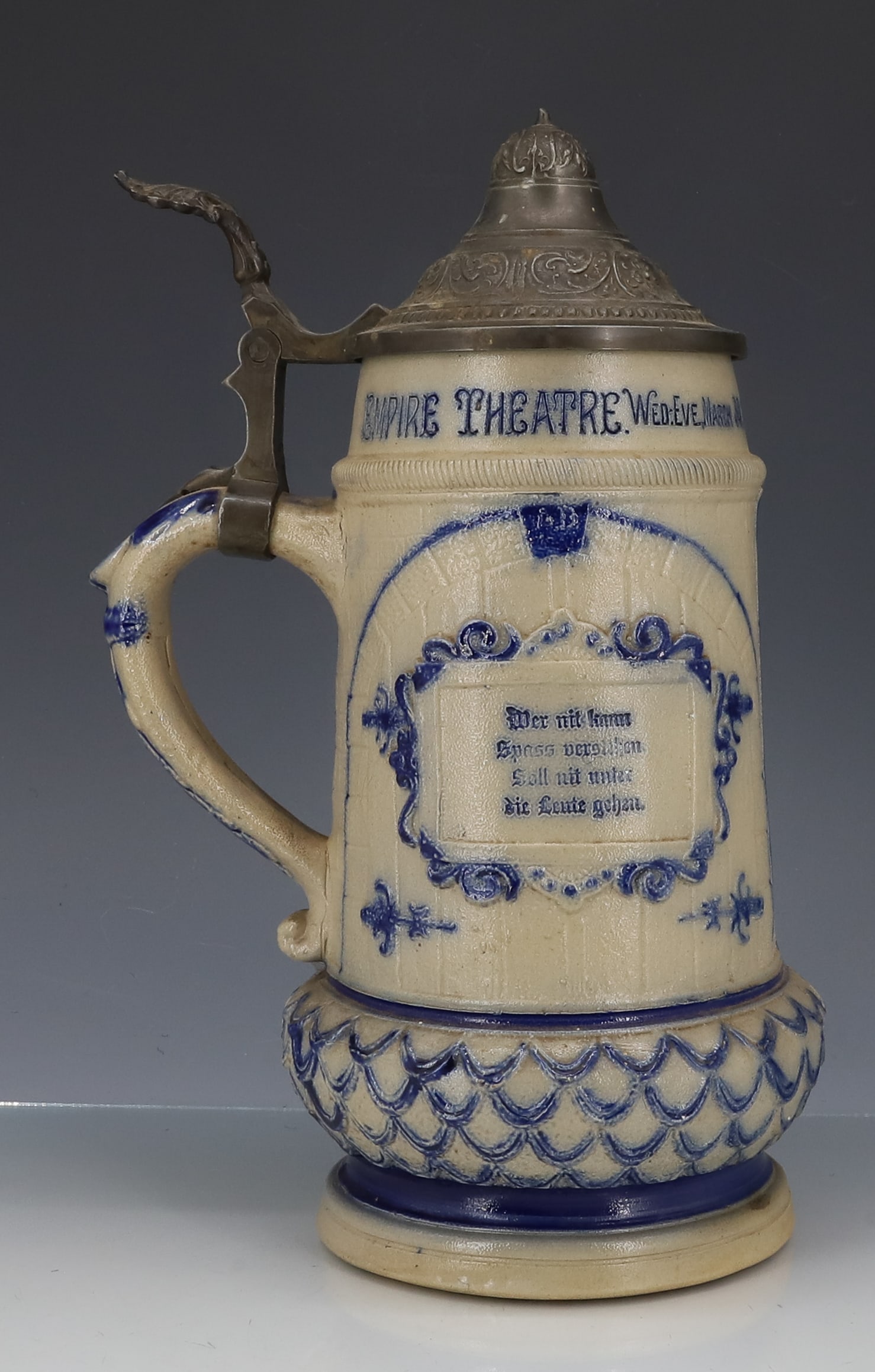 COMMEMORATIVE WHITE'S UTICA STEIN, TANKARD: "EMPIRE THEATRE, WED-EVE, MARCH 30, 100TH PERFORMANCE, THE CONQUERORS" MOLDED WITH COBALT HIGHLIGHTS. PEWTER LID. MRKD. 39 ON BOTTOM. 10 1/2" TOTAL HEIGHT. STEIN IS 8 3/8" H. PLEASE READ CAREFULLY - I