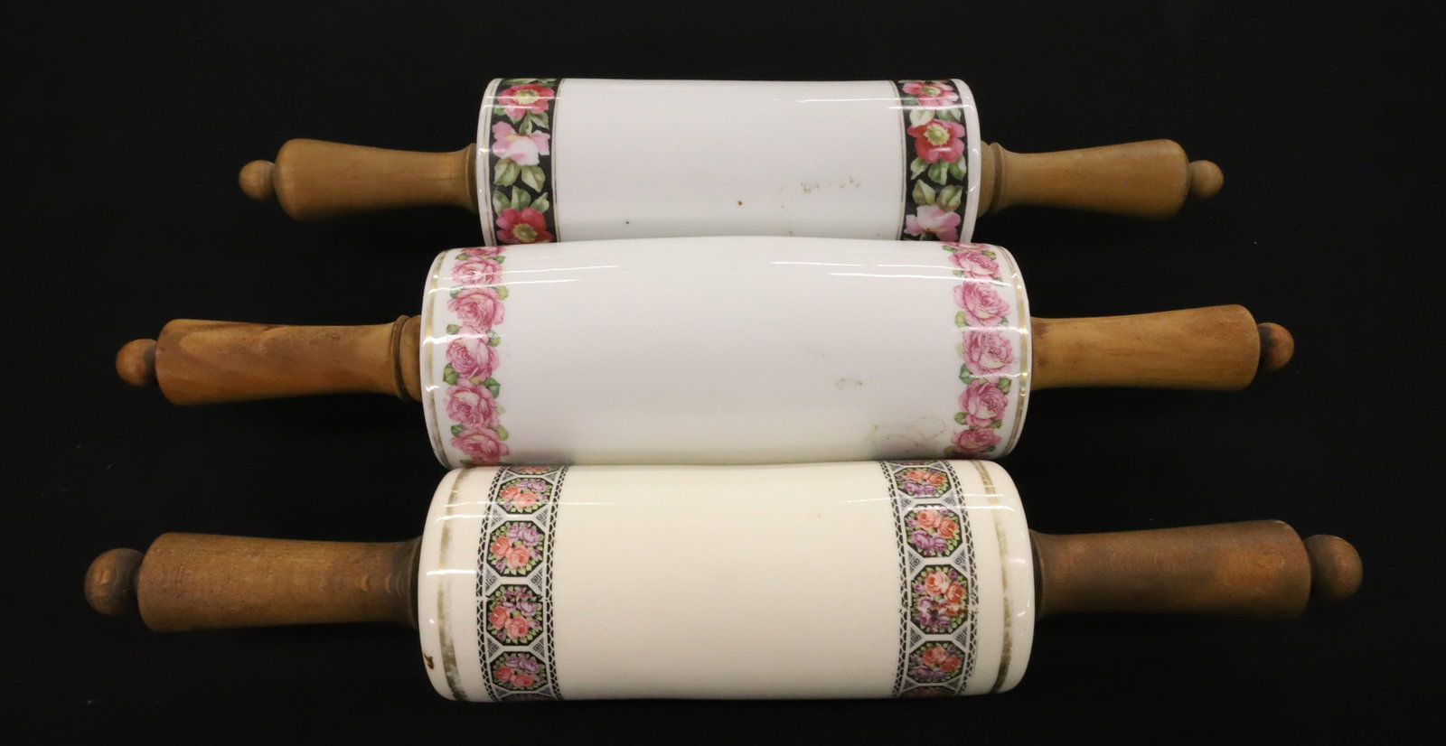 (3) CERAMIC DECORATED ROLLING PINS: FLORAL BANDING WITH WOODEN HAND GRIPS. SMALLEST STAMPED "CZECHOSLOVAKIA". 14 1/4" TO 15 1/2". PLEASE READ CAREFULLY - ITEMS MUST BE PAID FOR THROUGH LIVE AUCTIONEERS OR WITH CASH OR CHECK IN PERSON - 