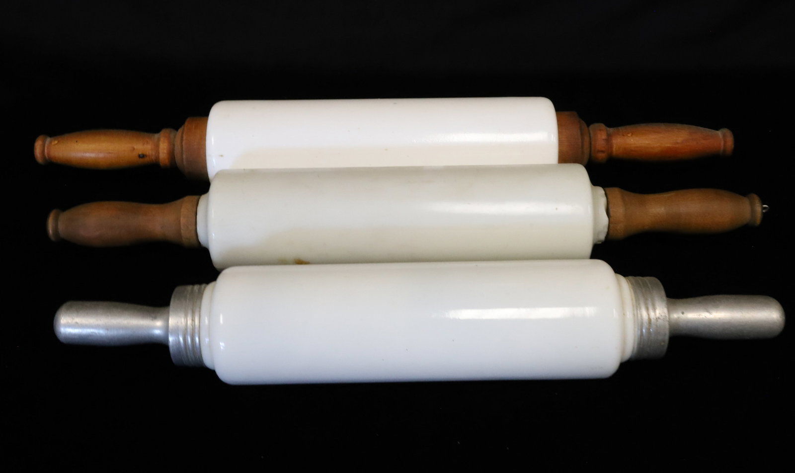 (3) MILK GLASS ROLLING PINS: ONE HAS ALUMINUM HAND GRIPS, THE OTHER TWO ARE WOODEN. 16 1/2" TO 18" LENGTHS. PLEASE READ CAREFULLY - ITEMS MUST BE PAID FOR THROUGH LIVE AUCTIONEERS OR WITH CASH OR CHECK IN PERSON - Terms for Purch