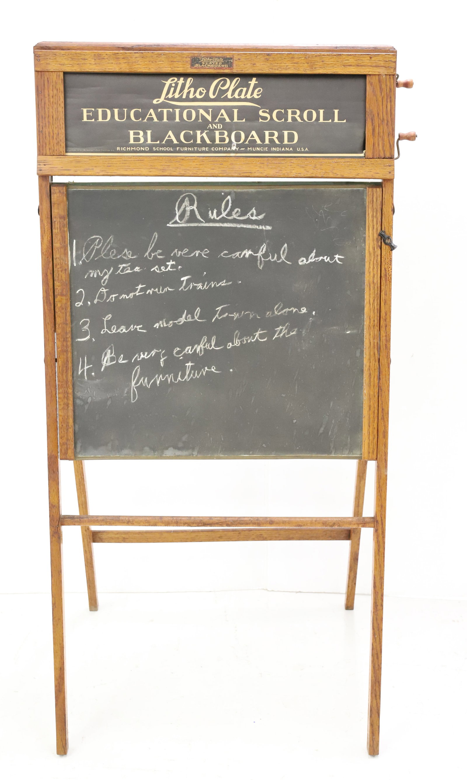 ANTIQUE "LITHO PLATE" SCROLLING BLACKBOARD: OAK FRAME WITH PAPER SCROLL FOR WINDING AT TOP ABOVE SLATED FINISH BOARD. 40 1/4" H. COPYRIGHT 1936. PLEASE READ CAREFULLY - ITEMS MUST BE PAID FOR THROUGH LIVE AUCTIONEERS OR WITH CASH OR CHECK IN PE