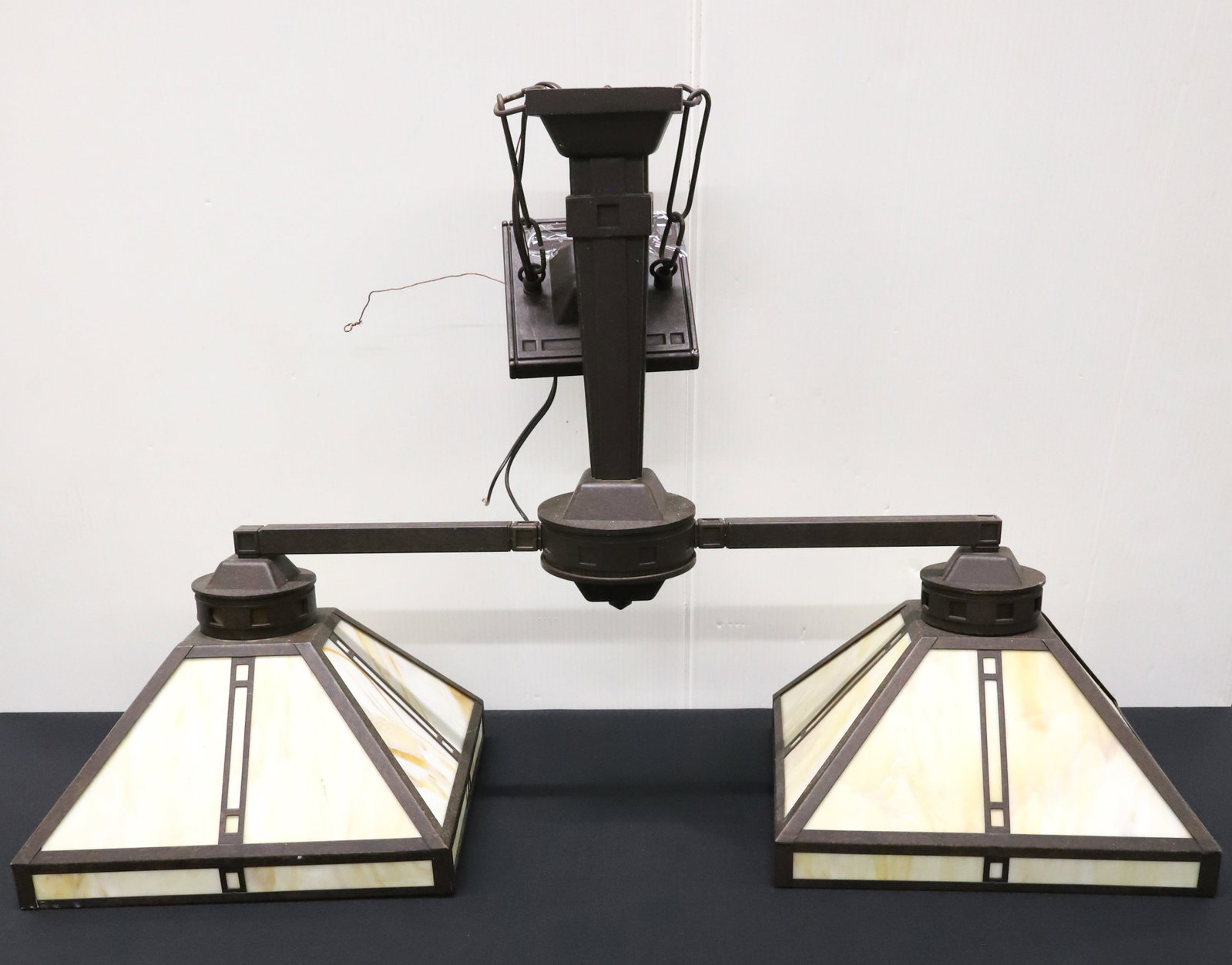 ARTS AND CRAFT-STYLE HANGING LAMP: CONTEMPORARY TWO SHADE LIGHT. SWIRL GLASS INSERTS ON FAUX BRONZE FRAMEWORK. 20 1/2" X 32 1/2" X 12". PLEASE READ CAREFULLY - ITEMS MUST BE PAID FOR THROUGH LIVE AUCTIONEERS OR WITH CASH OR CHECK IN PE