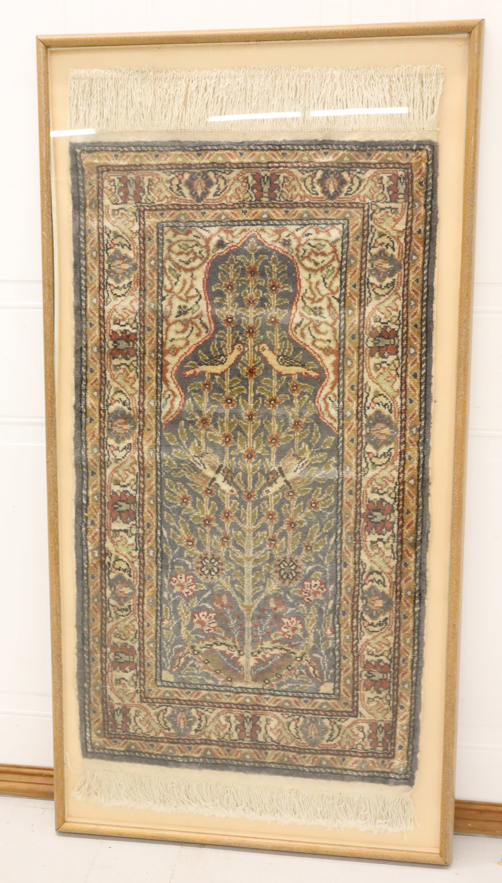 HANDMADE TURKISH RUG IN DISPLAY CASE: HAND-KNOTTED PRAYER RUG WITH TREE OF LIFE MOTIF WITH FLORAL AND BIRDS. MULTIPLE BORDERS AND FRINGE. RUG IS 41" X 22 1/2" (WITHOUT FRINGE). TOTAL SIZE IN WALL HANGING CASE 53 1/2" X 27 1/4". PLEASE