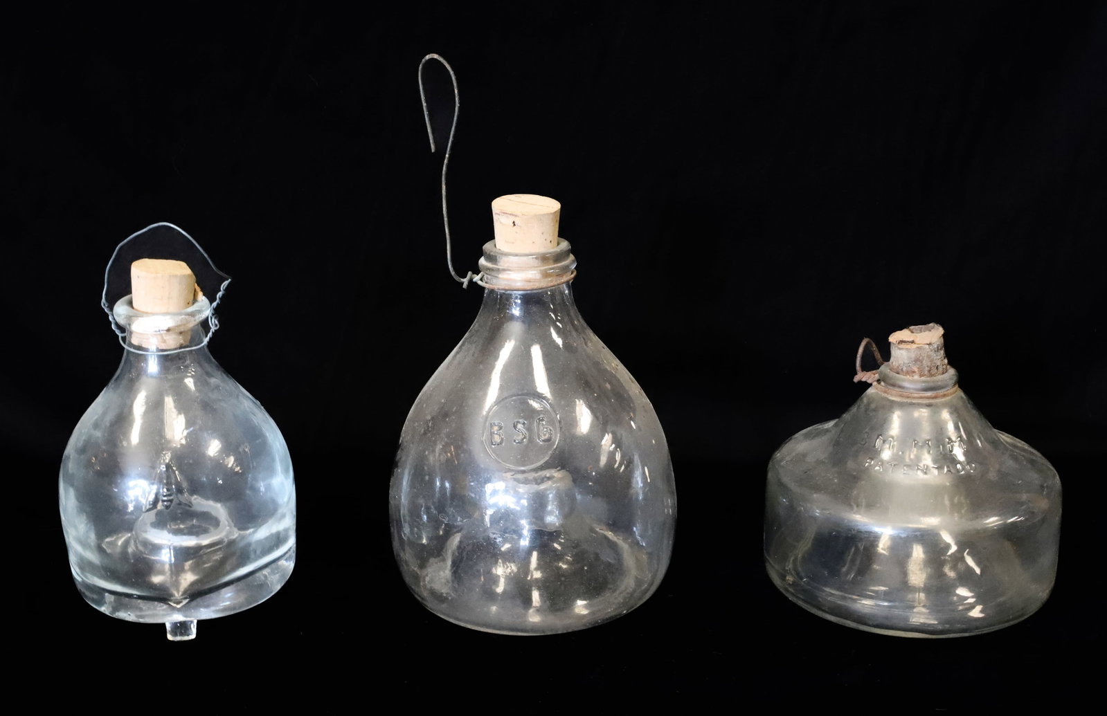 (3) GLASS FLY CATCHERS: SMALLEST IS MRKD. "3MMMA, PATENTADO" 3 3/4" X 4 5/8". NEXT SIZE HAS EMBOSSED FLY ON EITHER SIDE WITH APPLIED FEET. 5 1/4" X 3 1/2". LARGEST MRKD. "BSG" 5 3/4" X 4 1/2". PLEASE READ CAREFULLY - ITEMS M