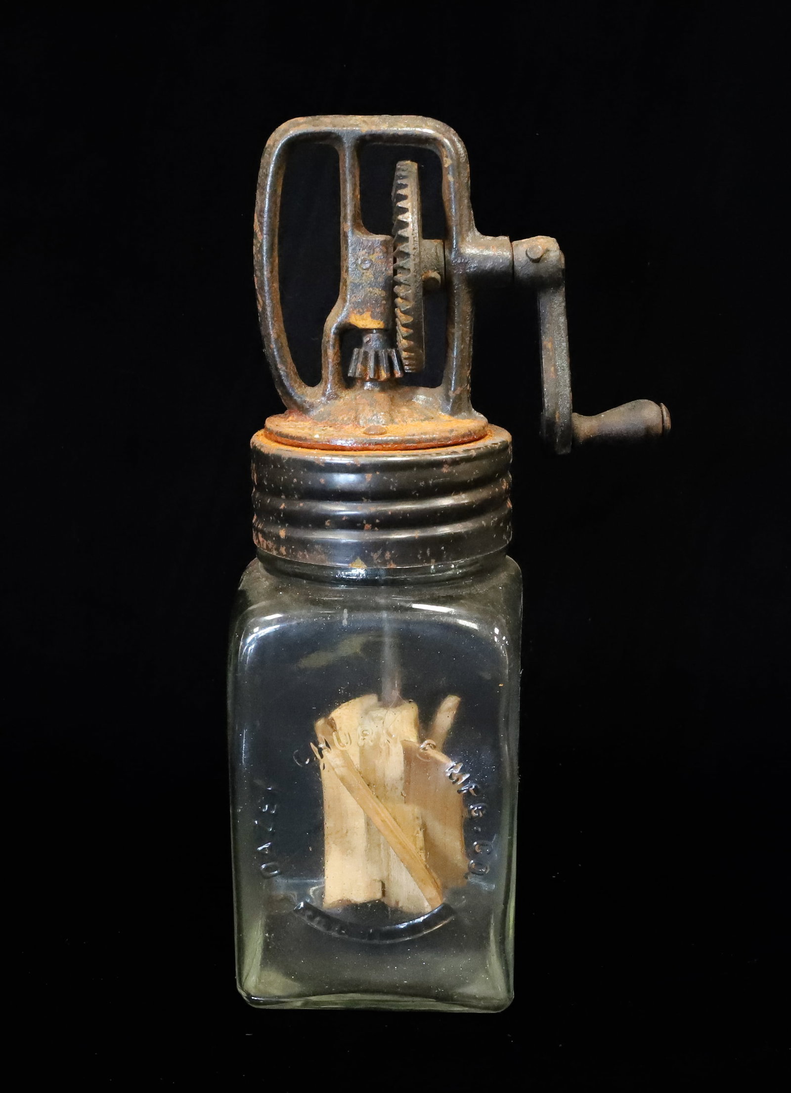 ANTIQUE "DAZEY" GLASS BUTTER CHURN: EMBOSSED GLASS AND METAL AND CAST IRON LID AND CRANK. WOODEN PADDLES. 11 1/4" H. PLEASE READ CAREFULLY - ITEMS MUST BE PAID FOR THROUGH LIVE AUCTIONEERS OR WITH CASH OR CHECK IN PERSON - Terms for