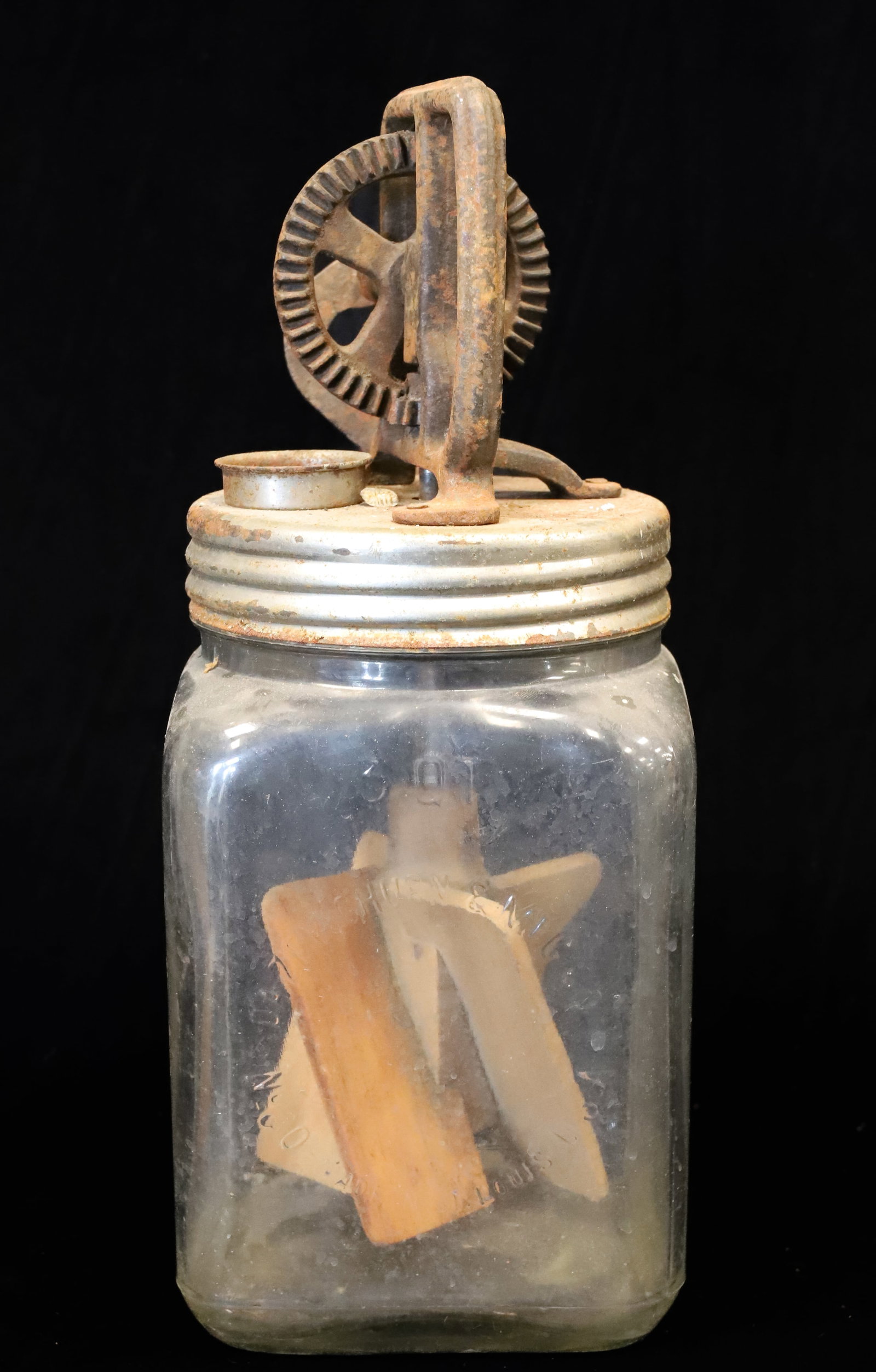 ANTIQUE "DAZEY" 3 QT. BUTTER CHURN: EMBOSSED GLASS AND METAL AND CAST IRON LID AND CRANK. WOODEN PADDLES. 13 1/4" H. PLEASE READ CAREFULLY - ITEMS MUST BE PAID FOR THROUGH LIVE AUCTIONEERS OR WITH CASH OR CHECK IN PERSON - Terms for