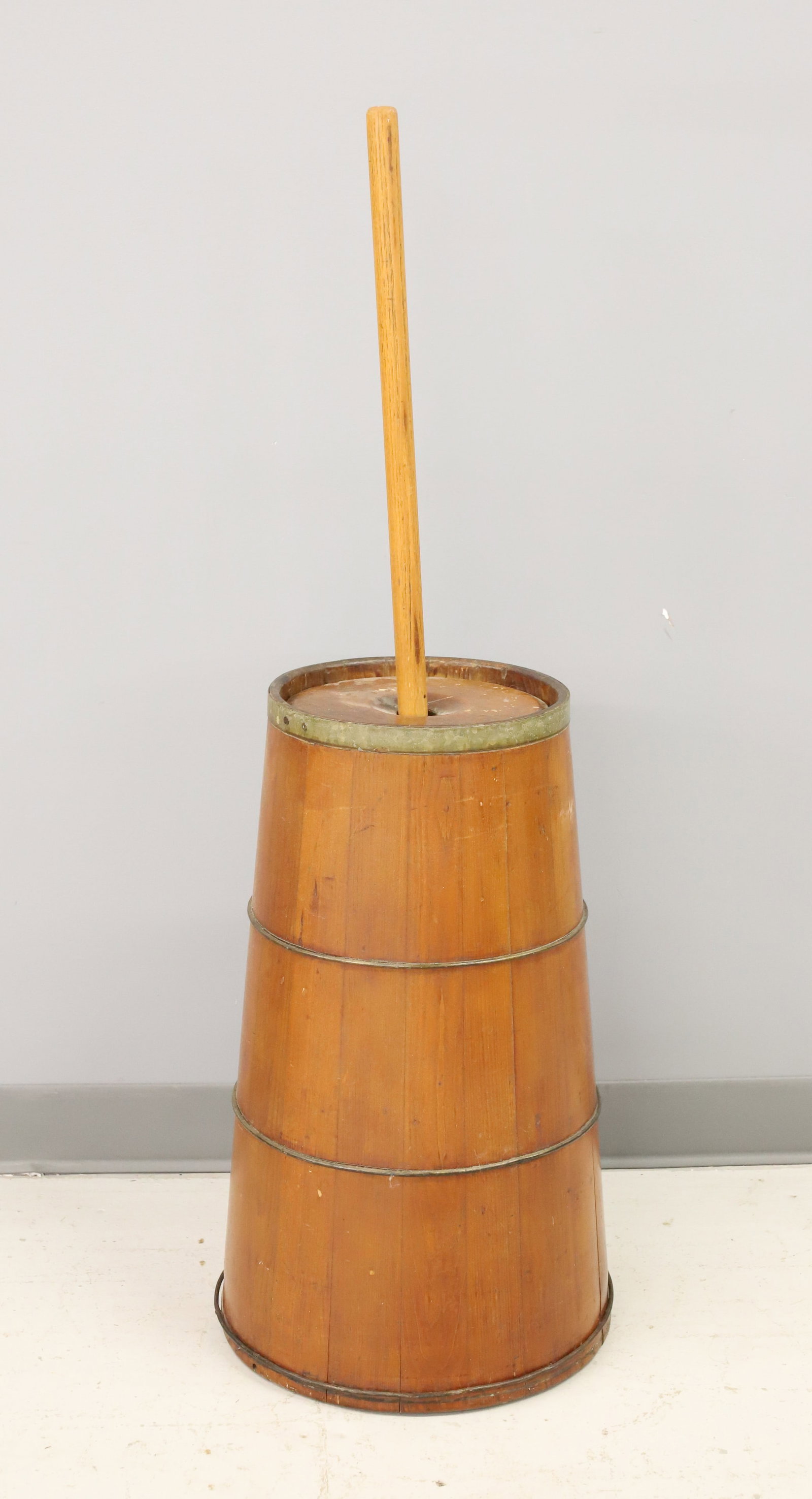 COUNTRY WOODEN BUTTER CHURN: CANTED SIDES WITH METAL BANDING. WOODEN PLUNGER. TOTAL HEIGHT 43". CHURN IS 23 3/4". PLEASE READ CAREFULLY - ITEMS MUST BE PAID FOR THROUGH LIVE AUCTIONEERS OR WITH CASH OR CHECK IN PERSON - Terms