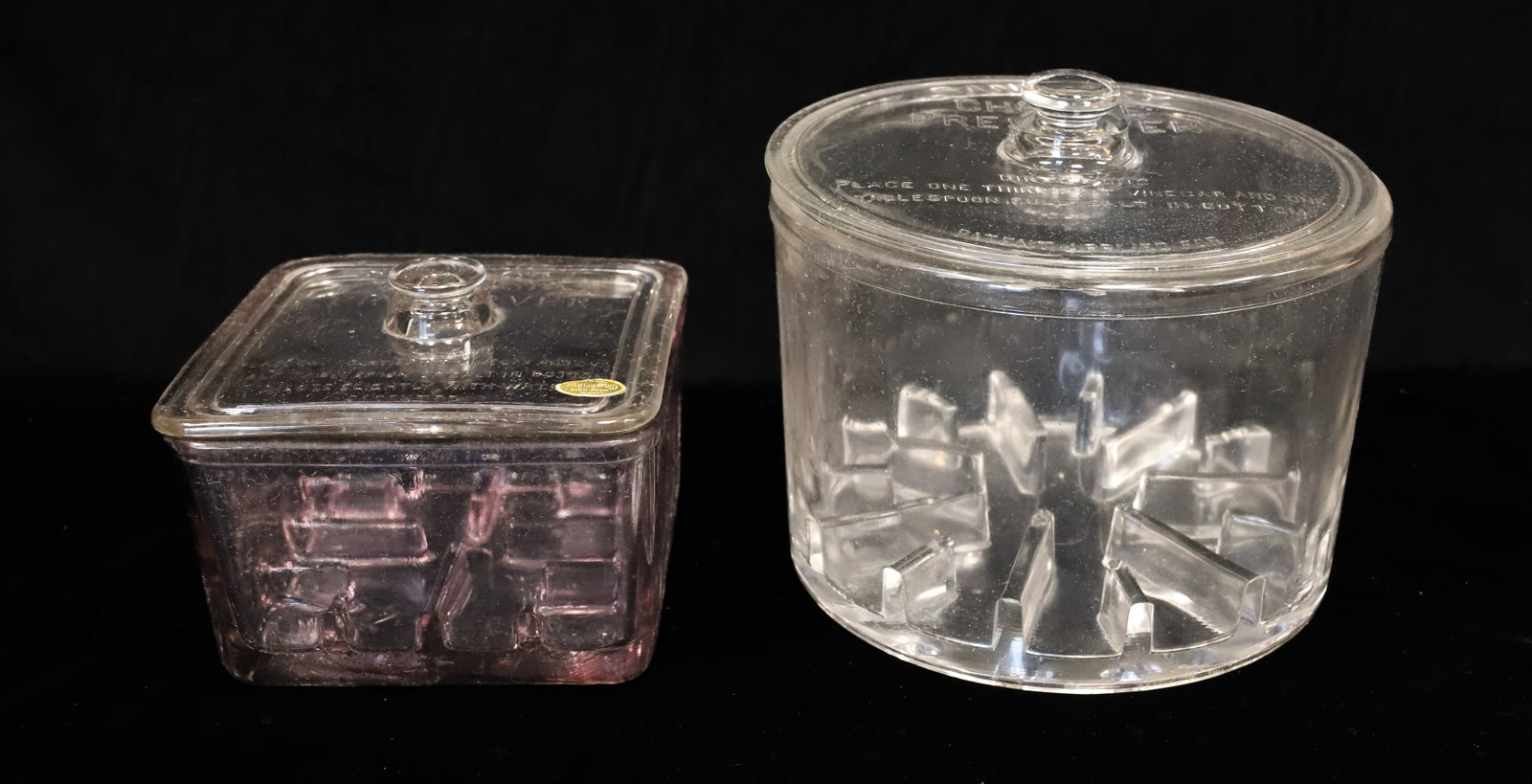 (2) GLASS "SANITARY CHEESE PRESERVER" JARS: SMALLER SQUARE JAR W/ MATCHING LID. BOTTOM HAS AMETHYST CAST TO GLASS. 3 1/2" X 5 1/4" X 5 1/4". LARGER 5 1/4" X 7 1/2". PLEASE READ CAREFULLY - ITEMS MUST BE PAID FOR THROUGH LIVE AUCTIONEERS OR