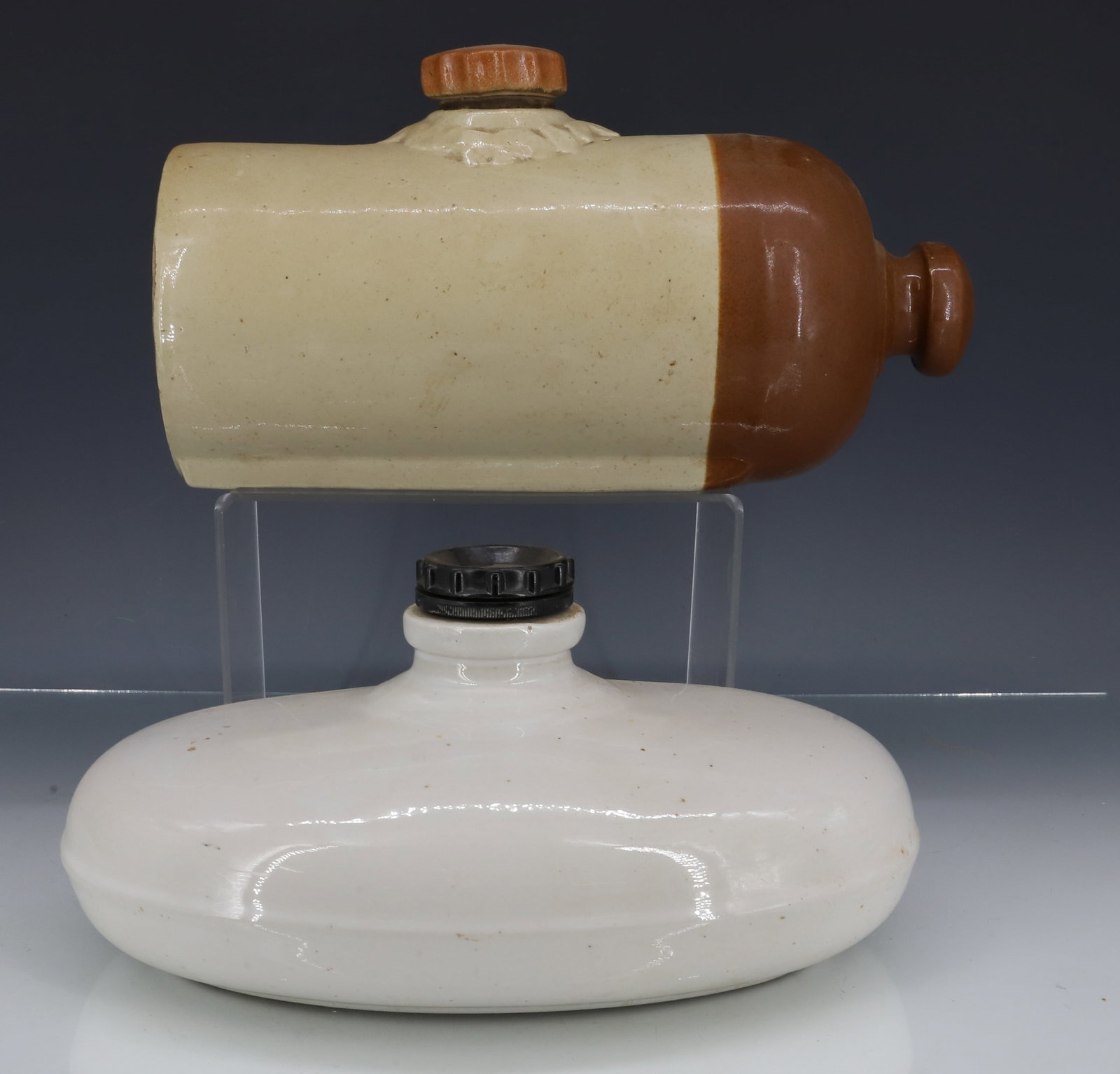 (2) STONEWARE FOOT WARMERS: BROWN / WHITE GLAZED EXAMPLE MRKD. "MEDALTA POTTERIES LTD. MEDICINE HAT ALBERTA" 11 1/2" L. WHITE OVAL EXAMPLE MRKD. ON BOTTOM WITH MOLDED PLASTIC SCREW CAP. PLEASE READ CAREFULLY - ITEMS MUST BE PAID