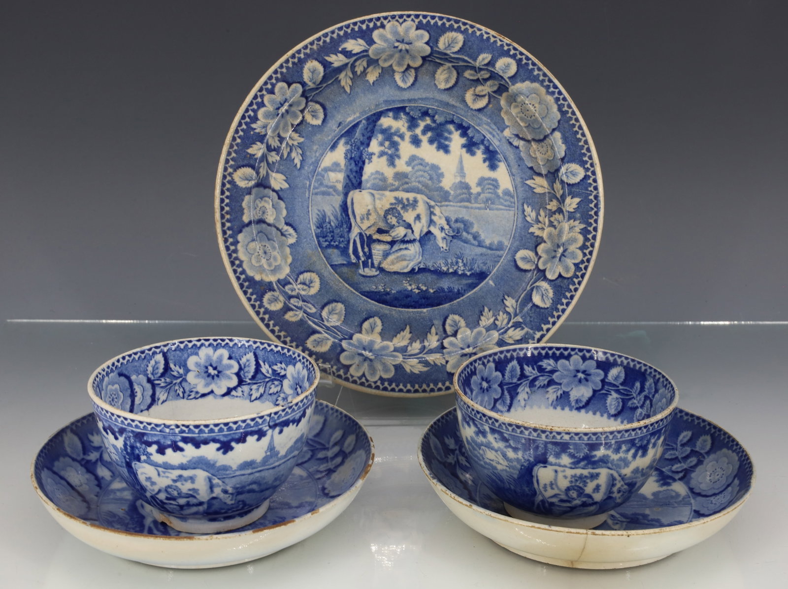 LOT OF HISTORICAL BLUE TRANSFERWARE: BLUE / WHITE PATTERN WITH WOMAN MILKING A COW. PLATE 7 1/2" D. WITH TWO CUPS/SAUCERS. PLEASE READ CAREFULLY - ITEMS MUST BE PAID FOR THROUGH LIVE AUCTIONEERS OR WITH CASH OR CHECK IN PERSON - Terms fo