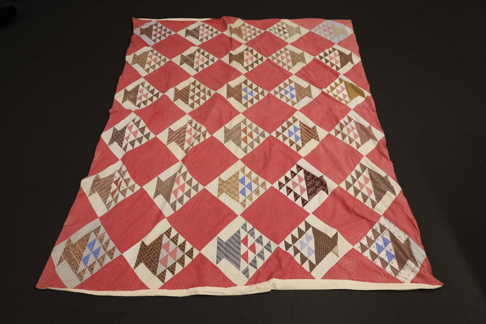 HAND STITCHED BASKET QUILT: VARIOUS COLORS AND PATTERNS WITH PINK PATTERNED BLOCKS. OFF-WHITE BACKING. 80" X 67". PLEASE READ CAREFULLY - ITEMS MUST BE PAID FOR THROUGH LIVE AUCTIONEERS OR WITH CASH OR CHECK IN PERSON - Terms fo