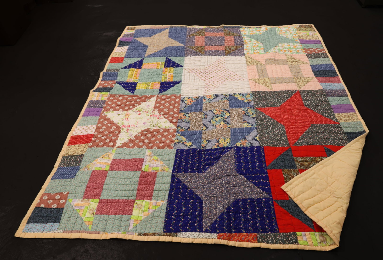 VINTAGE HANDMADE SOUTHERN QUILT: MACHINE SEWN AND HAND STITCHED. SAMPLER QUILT WITH VARIOUS COLORS AND PATTERNS. 96" X 83". TAGGED "HANDMADE BY WOMEN OF TUTWILER, MS" PLEASE READ CAREFULLY - ITEMS MUST BE PAID FOR THROUGH LIVE AUCTIO