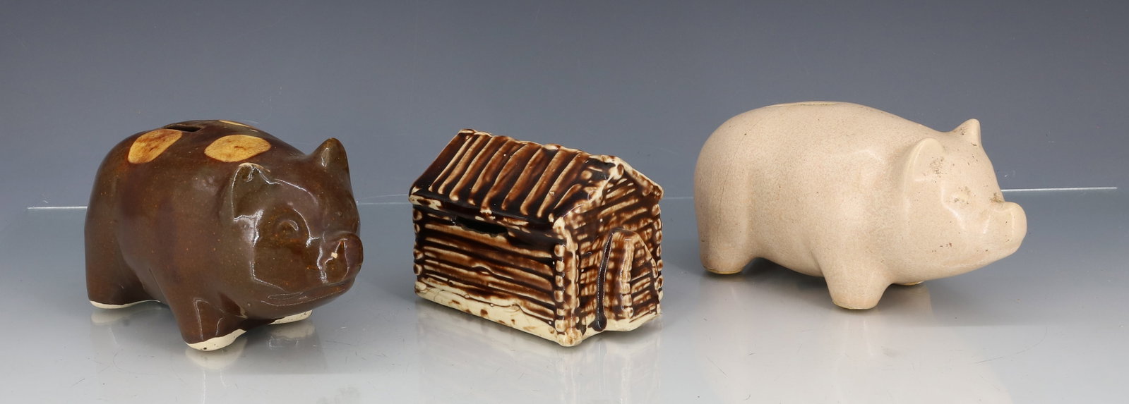 (3) POTTERY BANKS: GLAZED LOG CABIN "HOUSE IN WHICH ABRAHAM LINCOLN WAS BORN....AUSTRIA" VAN DYK TEAS. 3 3/4" L. BROWN GLAZED PIG WITH YELLOW SPOTS. 5 1/2" L. WITH, OFF-WHITE PIG BANK. PLEASE READ CAREFULLY - ITEMS