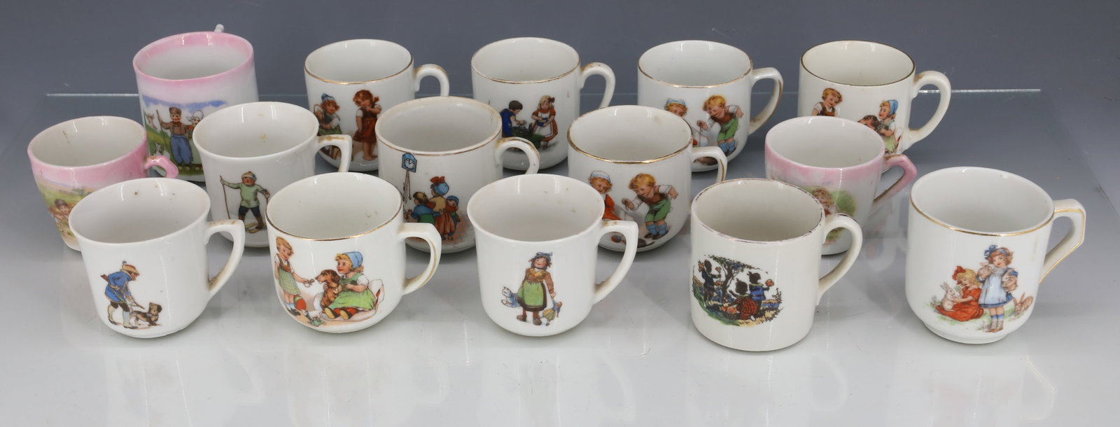COLLECTION OF (15) CHILDREN'S MUGS: VARIOUS DECORATED MUGS. UNMARKED AND MRKD. GERMANY. AVERAGE SIZE 2" X 2". PLEASE READ CAREFULLY - ITEMS MUST BE PAID FOR THROUGH LIVE AUCTIONEERS OR WITH CASH OR CHECK IN PERSON - Terms for