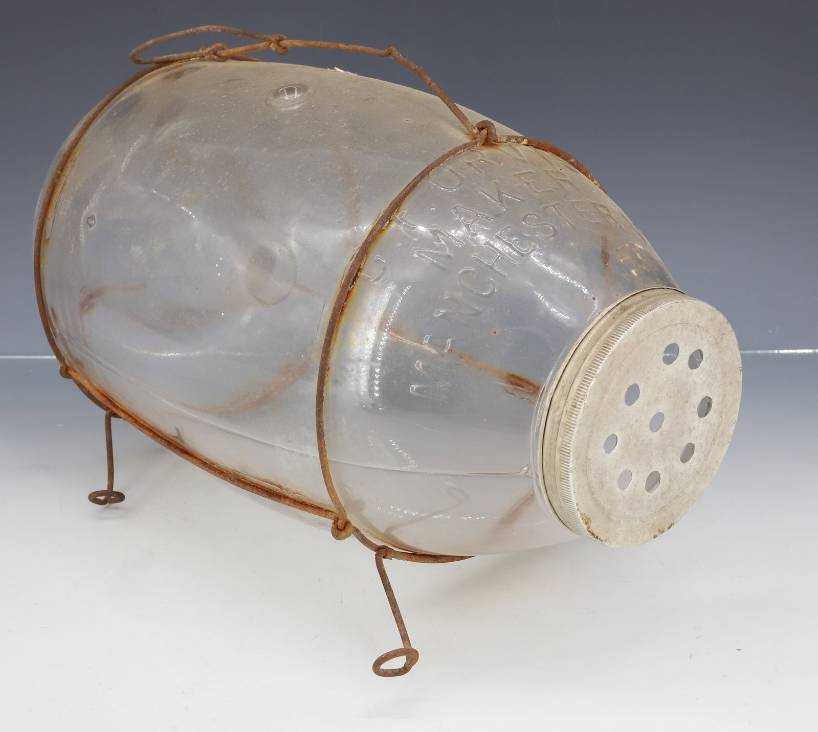 C.T. ORVIS GLASS MINNOW TRAP: CLEAR EMBOSSED GLASS "C.T. ORVIS, MAKER, MANCHESTER, VT" WIRE HANDLE AND FEET. METAL LID. 13" L. PLEASE READ CAREFULLY - ITEMS MUST BE PAID FOR THROUGH LIVE AUCTIONEERS OR WITH CASH OR CHECK IN