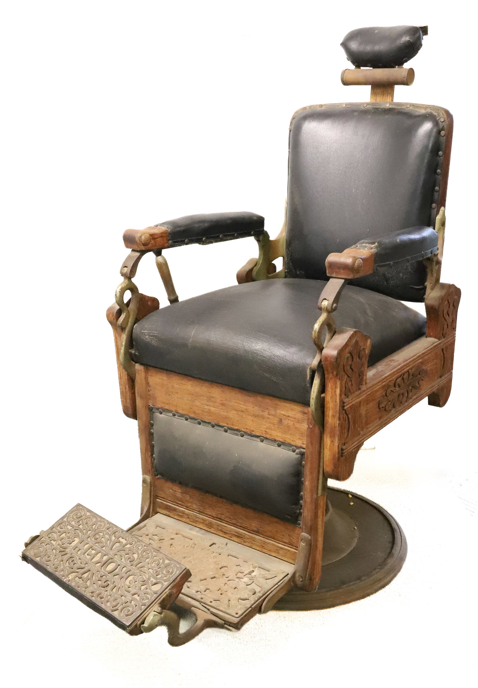 ANTIQUE KOKEN HYDRAULIC BARBER CHAIR: ADJUSTABLE HEADREST. ADJUSTABLE HEIGHT AND SWIVEL. LEATHER CUSHIONS. OAK AND METAL FRAMEWORK. MRKD. ON CAST IRON FOOTREST "KOKEN BARBER SUPPLY CO., ST. LOUIS" 49" X 23 1/2" X 42". PLEASE READ CAREFULL