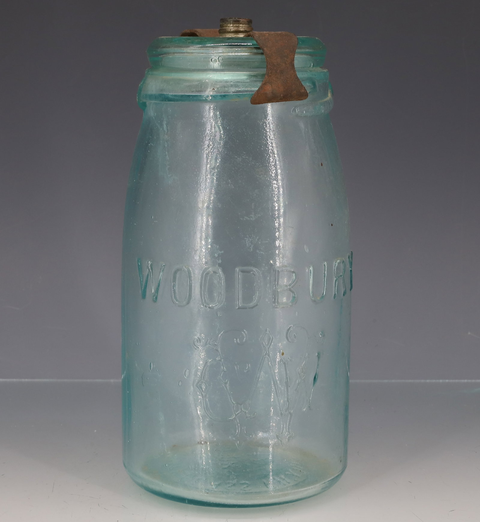 WOODBURY AQUA FRUIT JAR: AQUA JAR WITH EMBOSSED "WOODBURY" AND MONOGRAM ON FRONT. BOTTOM MRKD. "WOODBURY GLASS WORKS, WOODBURY, NJ, 12" GLASS LID MRKD. PATD. NOV 25TH 1884, MAR. 3D 85" IRON CLOSURE WITH METAL CAP (PATENT