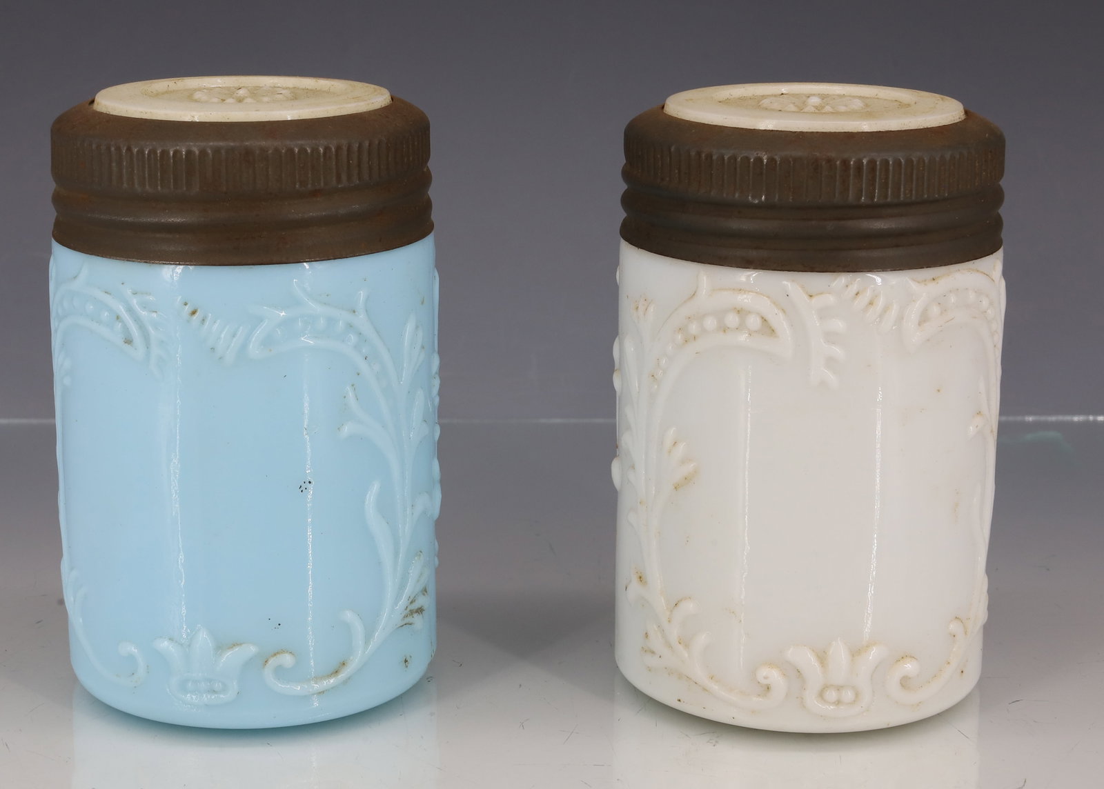 (2) MILK GLASS EMBOSSED FRUIT JARS: LIGHT BLUE JAR AND WHITE EMBOSSED JARS WITH WHITE INSERT LIDS. UNMARKED. 4 3/8" HEIGHTS. PLEASE READ CAREFULLY - ITEMS MUST BE PAID FOR THROUGH LIVE AUCTIONEERS OR WITH CASH OR CHECK IN PERSON -