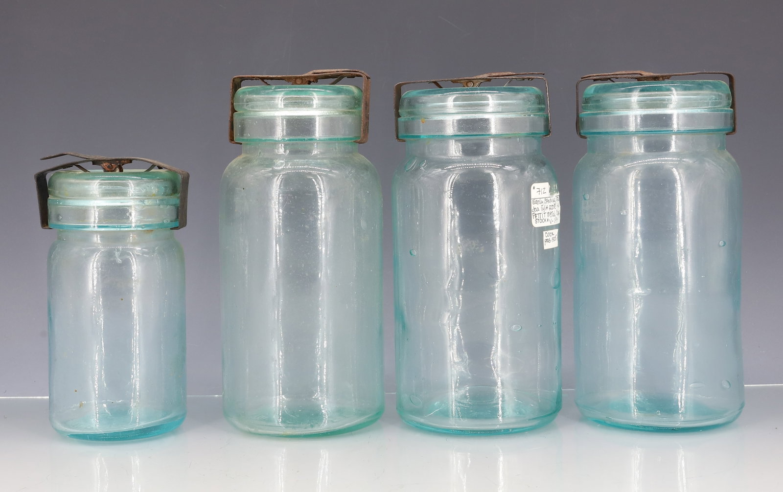 (4) H.W. PETTIT AQUA FRUIT JARS: AQUA JARS WITH MATCHING LIDS AND METAL CLOSURES. TWO SMALLER ARE MRKD. ON BOTTOM " H.W. PETTIT WESTVILLE, N.J." 5 3/4" X 3". 7 5/8" X 3 5/8". 7 3/8" X 3 3/4". PLEASE READ CAREFULLY - ITEMS MUST BE