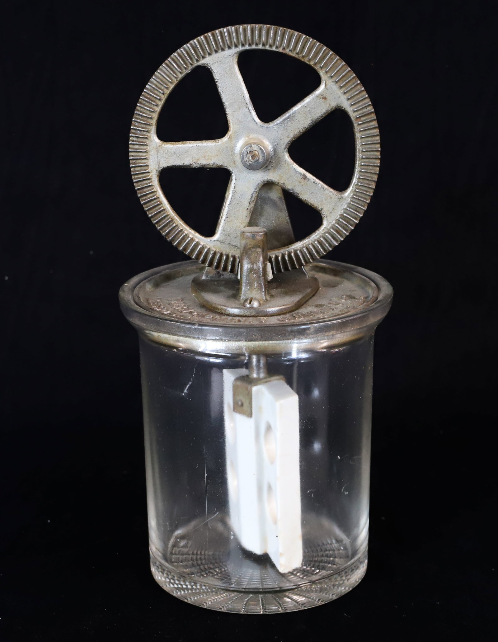 GLASS "TURN-A-MINIT CHURN": TABLETOP GLASS CHURN WITH CAST IRON TOP MRKD. "METROPOLITAN TOWER, NEW YORK" GLAZED POTTERY PADDLE. 11" H. PLEASE READ CAREFULLY - ITEMS MUST BE PAID FOR THROUGH LIVE AUCTIONEERS OR WITH CASH OR