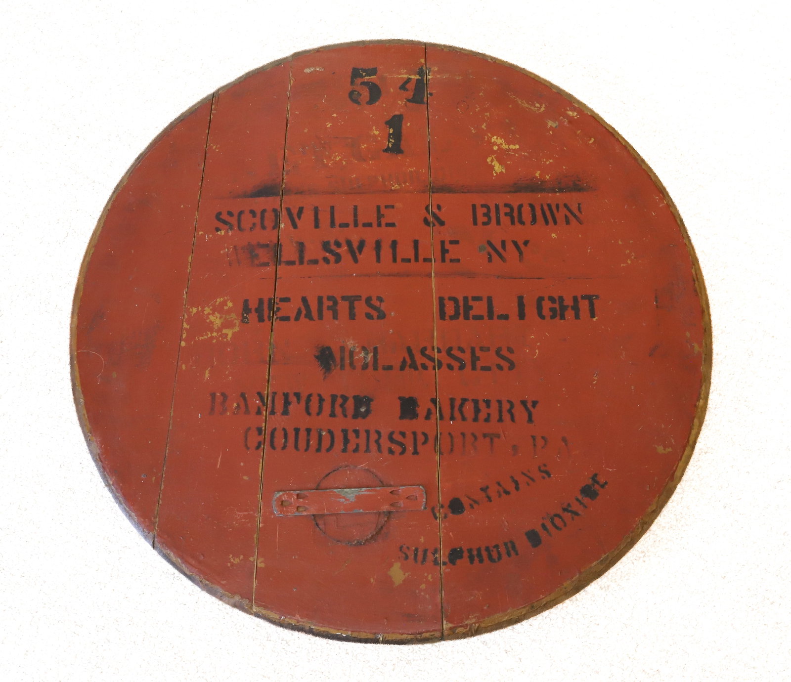PAINTED WOODEN ADVERTISING LID: RED PAINTED SURFACE WITH STENCIL ADVERTISING. "HEARTS DELIGHT MOLASSES, RAMFORD BAKERY, GOUDERSPORT, PA". 21" D. PLEASE READ CAREFULLY - ITEMS MUST BE PAID FOR THROUGH LIVE AUCTIONEERS OR WITH CASH