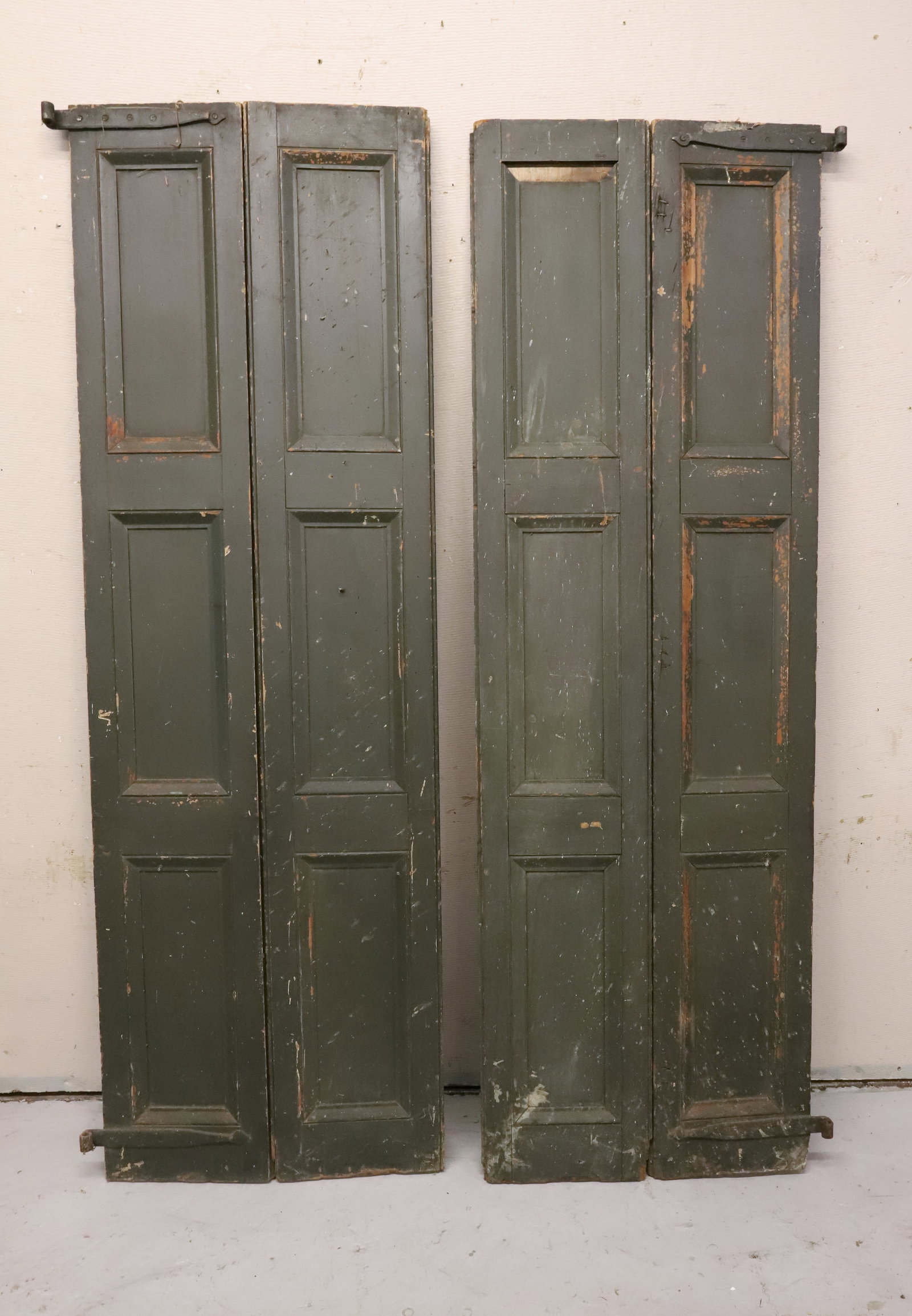 (2) PAIRS OF PAINTED SHUTTERS: TALL PANELED SHUTTERS IN DARK GREEN HINGED TOGETHER. IRON STRAP HINGES. 81" X 26" (WHEN OPENED). PLEASE READ CAREFULLY - ITEMS MUST BE PAID FOR THROUGH LIVE AUCTIONEERS OR WITH CASH OR CHECK IN PERSON